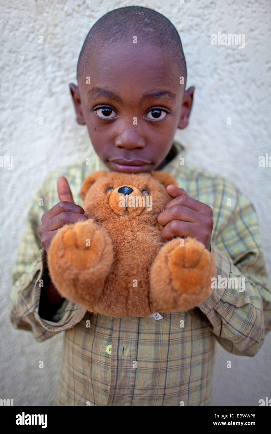 Ritratto di un giovane ragazzo, tenendo un orsacchiotto di peluche nelle sue mani, Burundi Bujumbura Mairie, Bujumbura Foto Stock