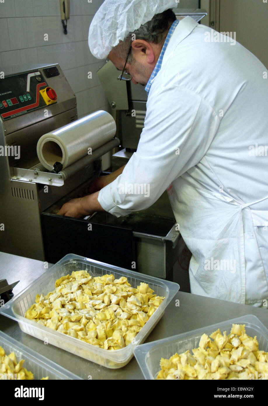 Uomo che lavora nella fabbrica di cibo per i ravioli Foto Stock