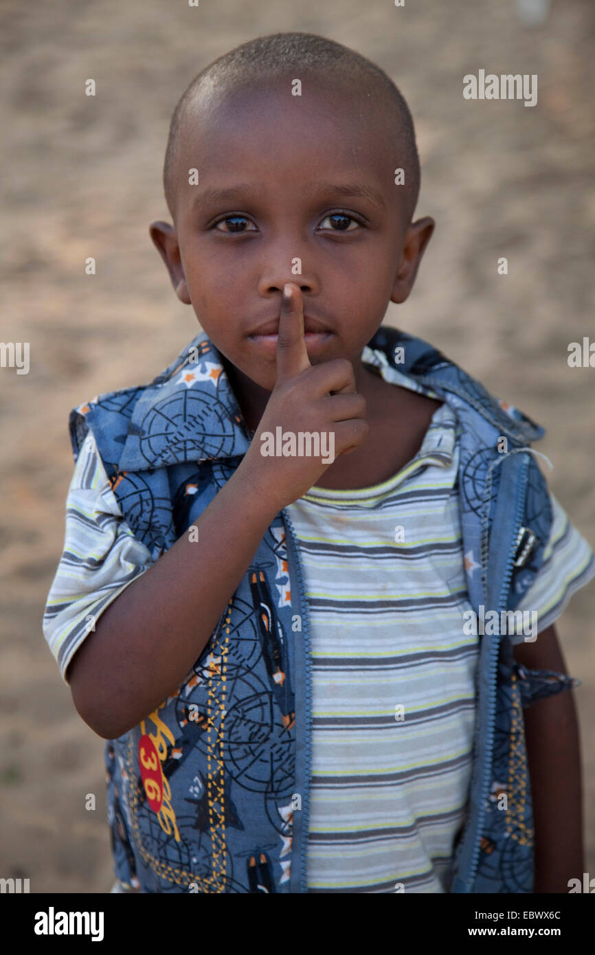 Ragazzino con il dito indice alla bocca sta chiedendo per il silenzioso, Burundi, Bujumbura Marie, Bujumbura Foto Stock