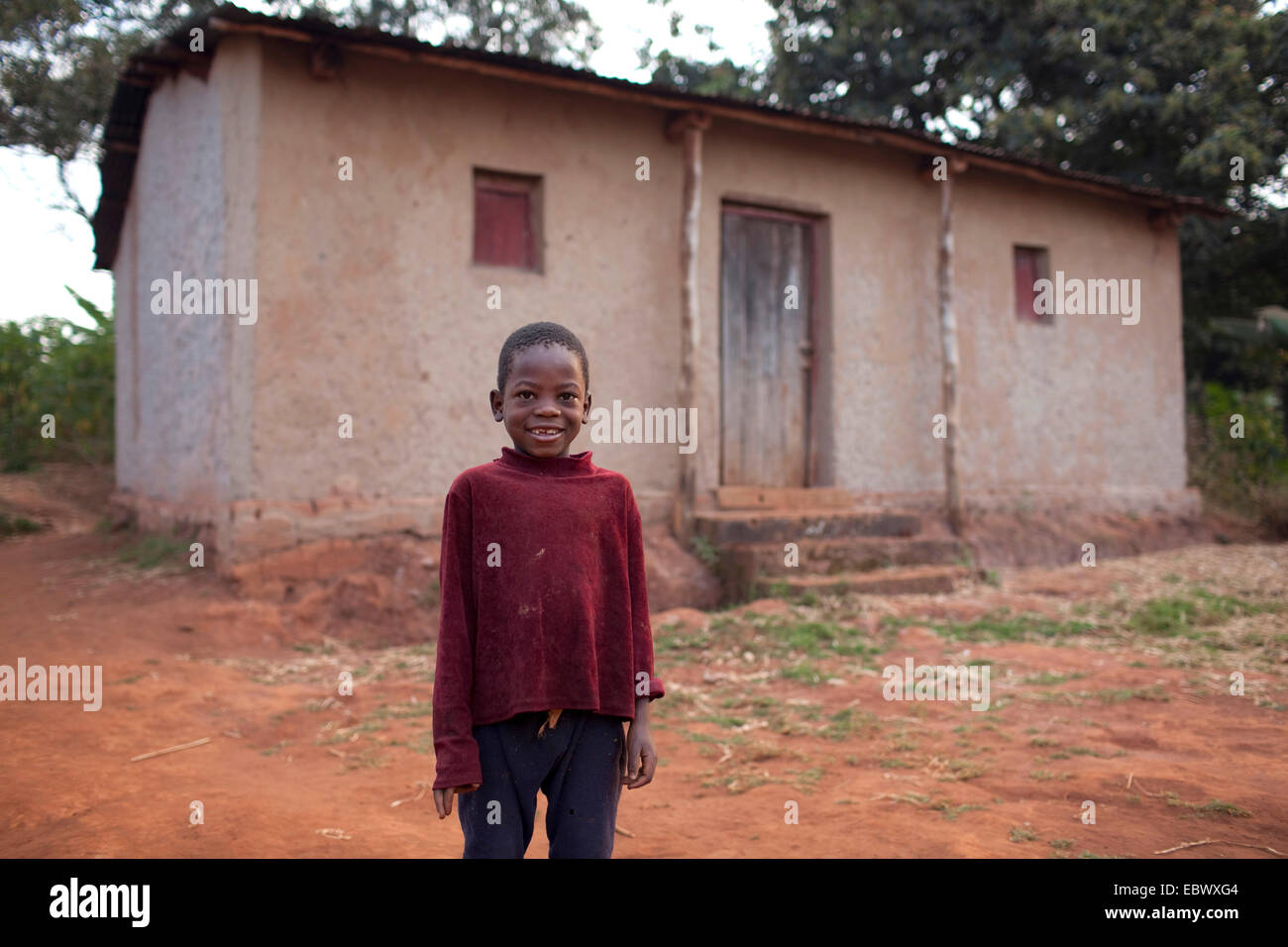 Little Boy in piedi di fronte ad un umile casa di campagna, Burundi, Karuzi, Buhiga Foto Stock