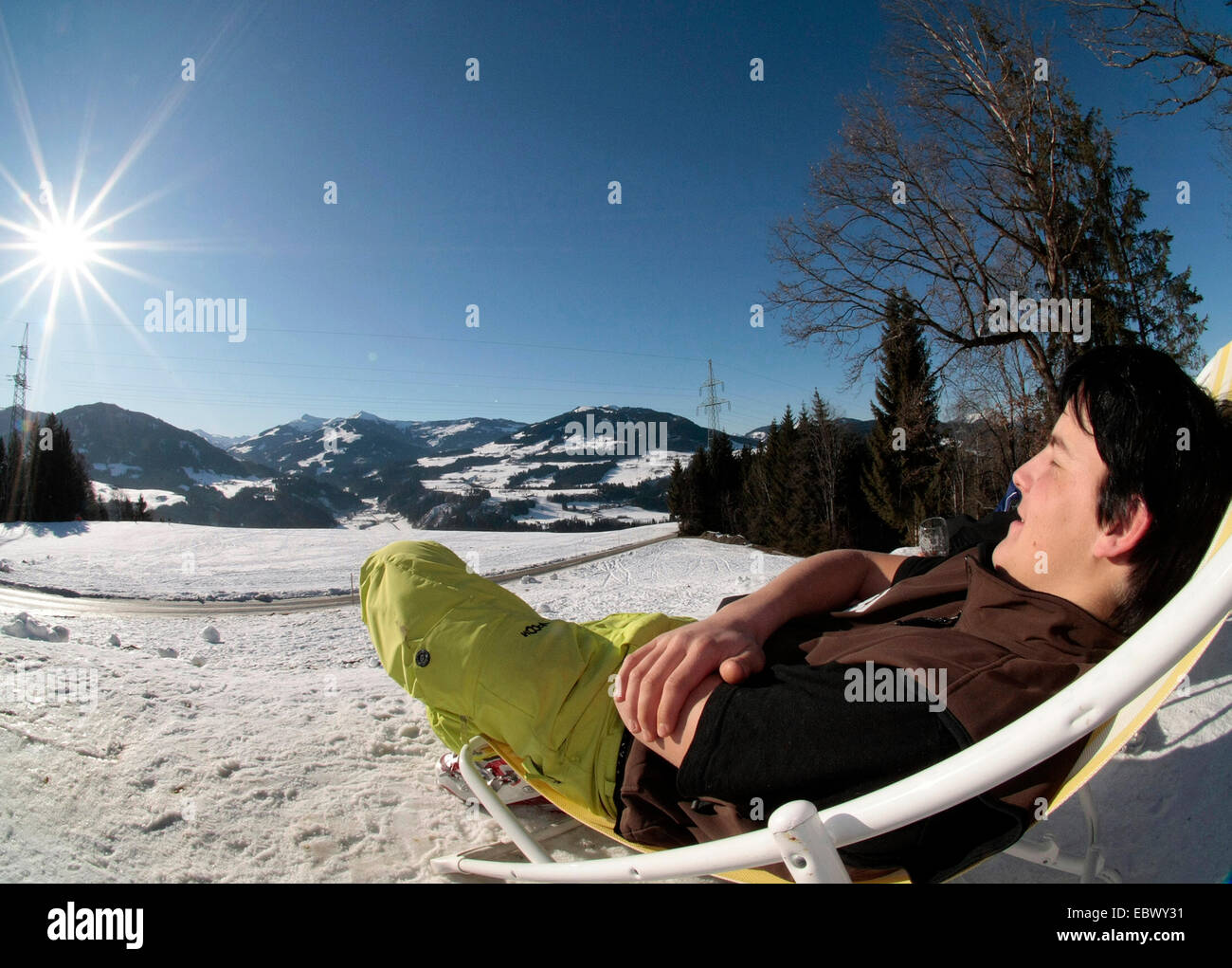 L'uomo rilassante nella neve su una sedia di canvas, Austria, Tirolo, Hopfgarten Foto Stock