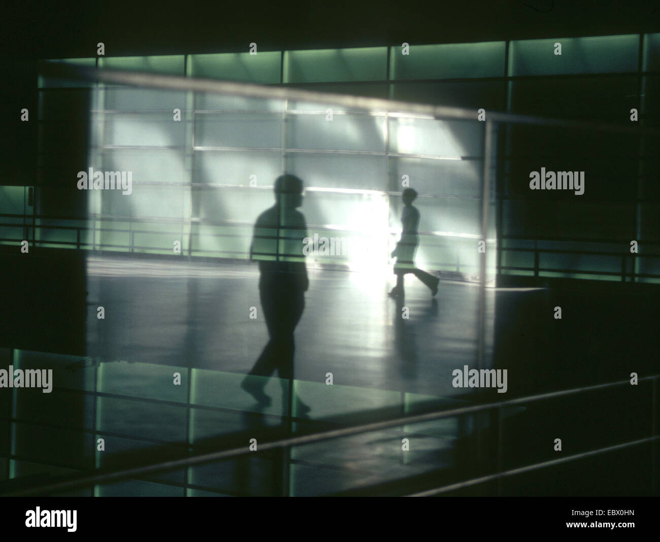 Sagome di due persone a piedi nella metropolitana si riflette in vetro Foto Stock