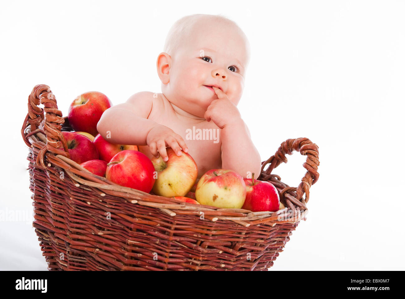 Dieci anni baby sitting in un cesto di frutta Foto Stock