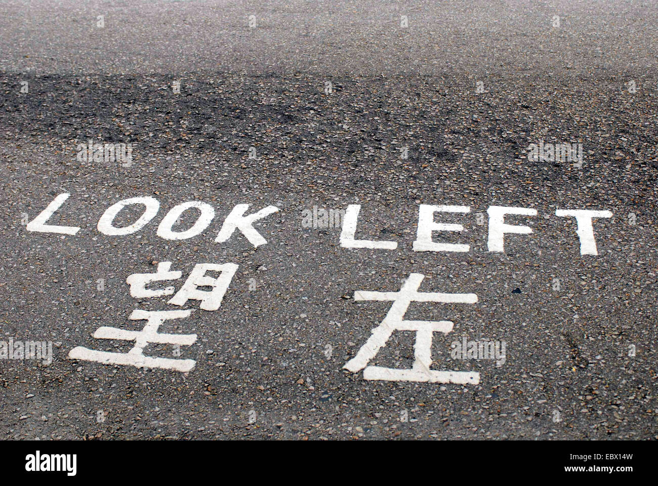Guardare a sinistra scritto su una strada in inglese e cinese, Cina, Hong Kong Foto Stock