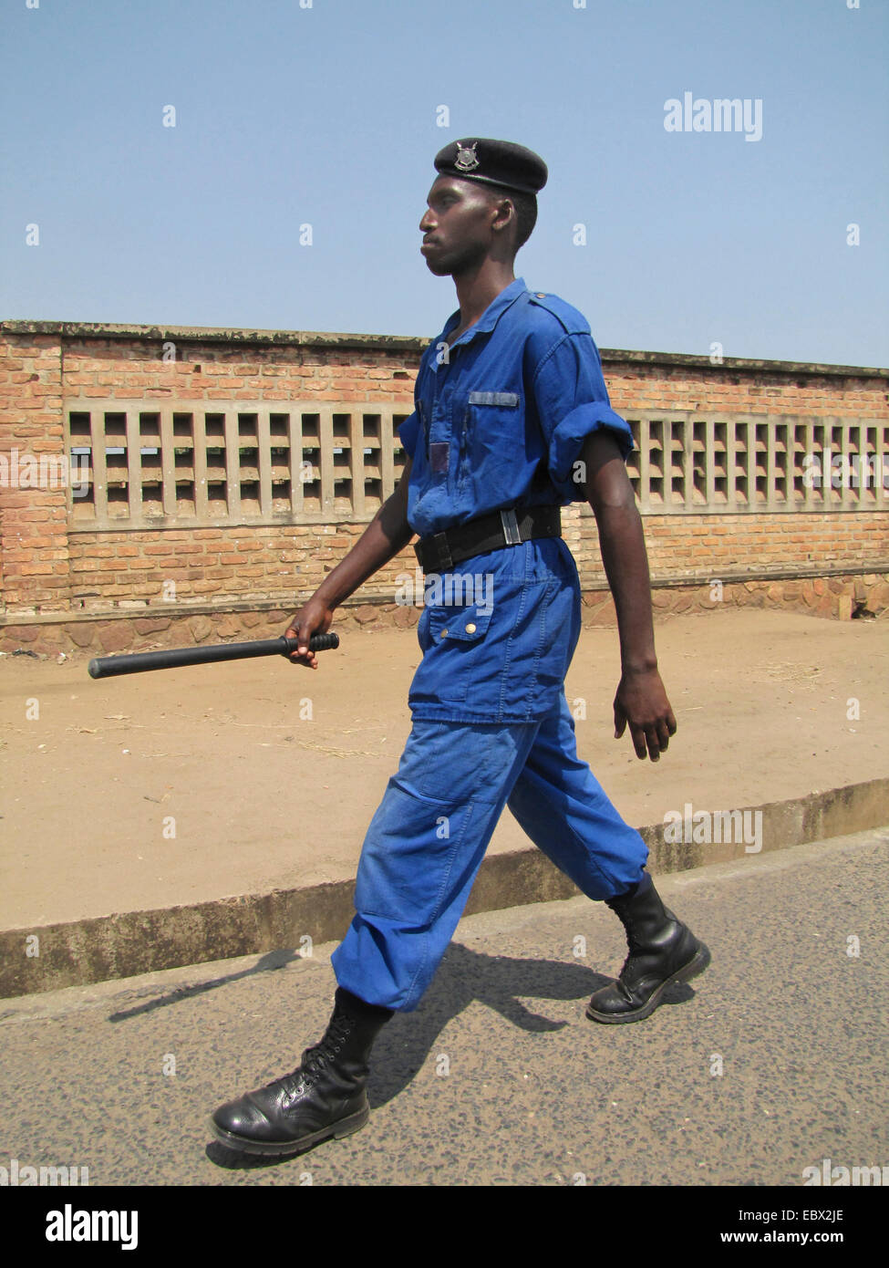 Funzionario di polizia con baton pattugliamento su una larga strada della capitale, Burundi Bujumbura marie, Rohero 1, Bujumbura Foto Stock