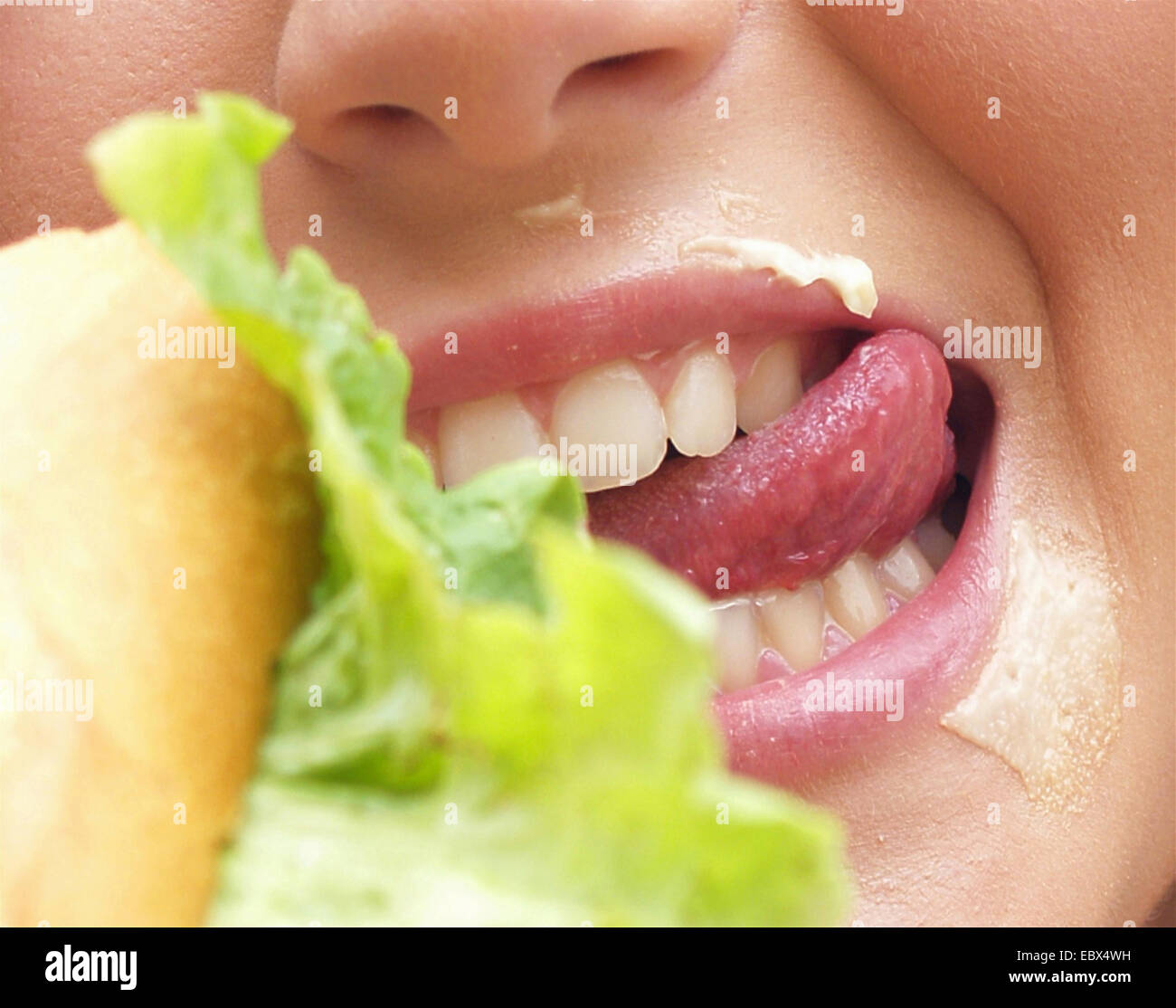 La bocca di una giovane donna hoggishly mangiare una baguette Foto Stock