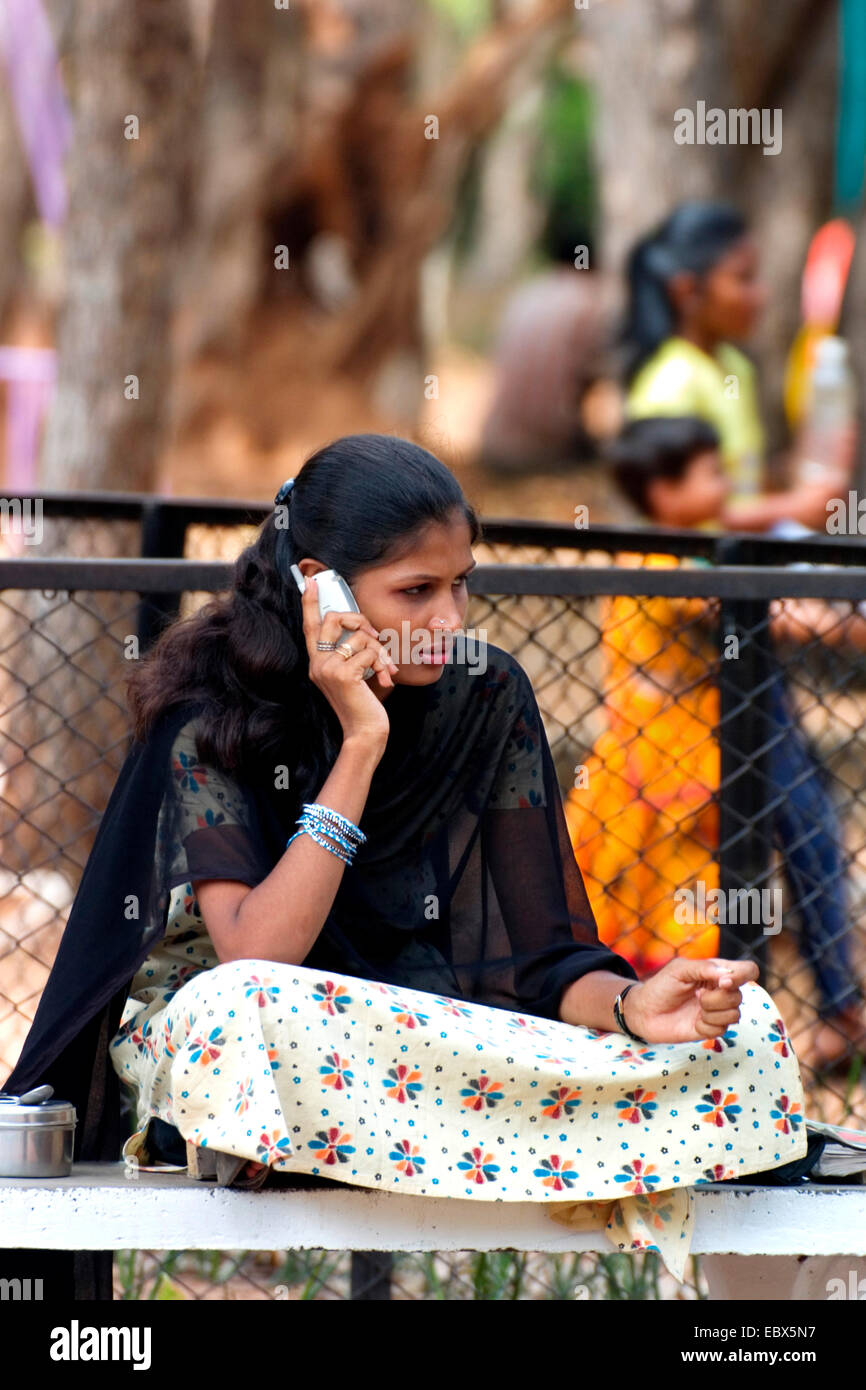 Giovane donna indiana con telefono cellulare nel parco per bambini, India Chennai, Madras Foto Stock