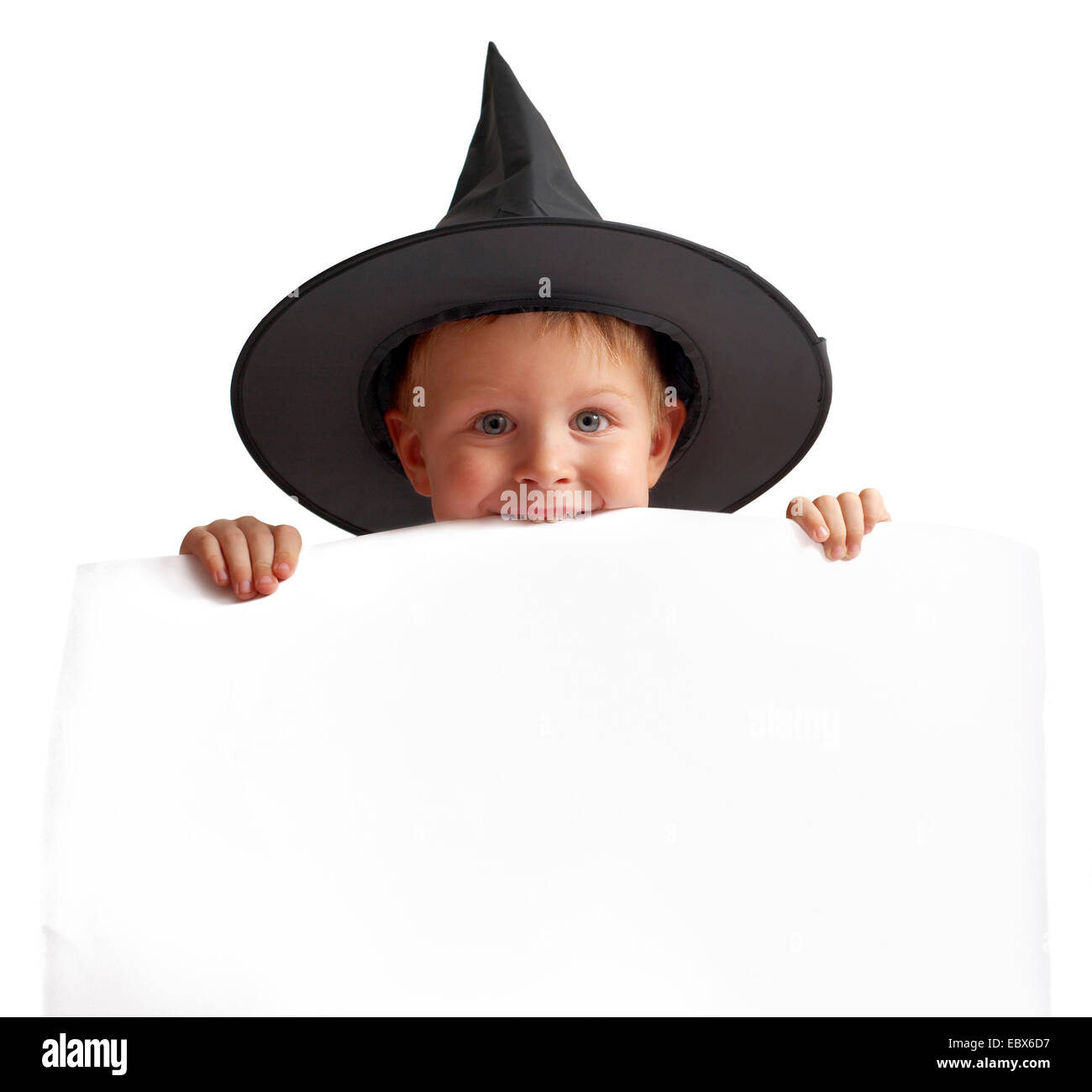 Giocoso ragazzo in witch hat detiene il banner bianco. Foto Stock