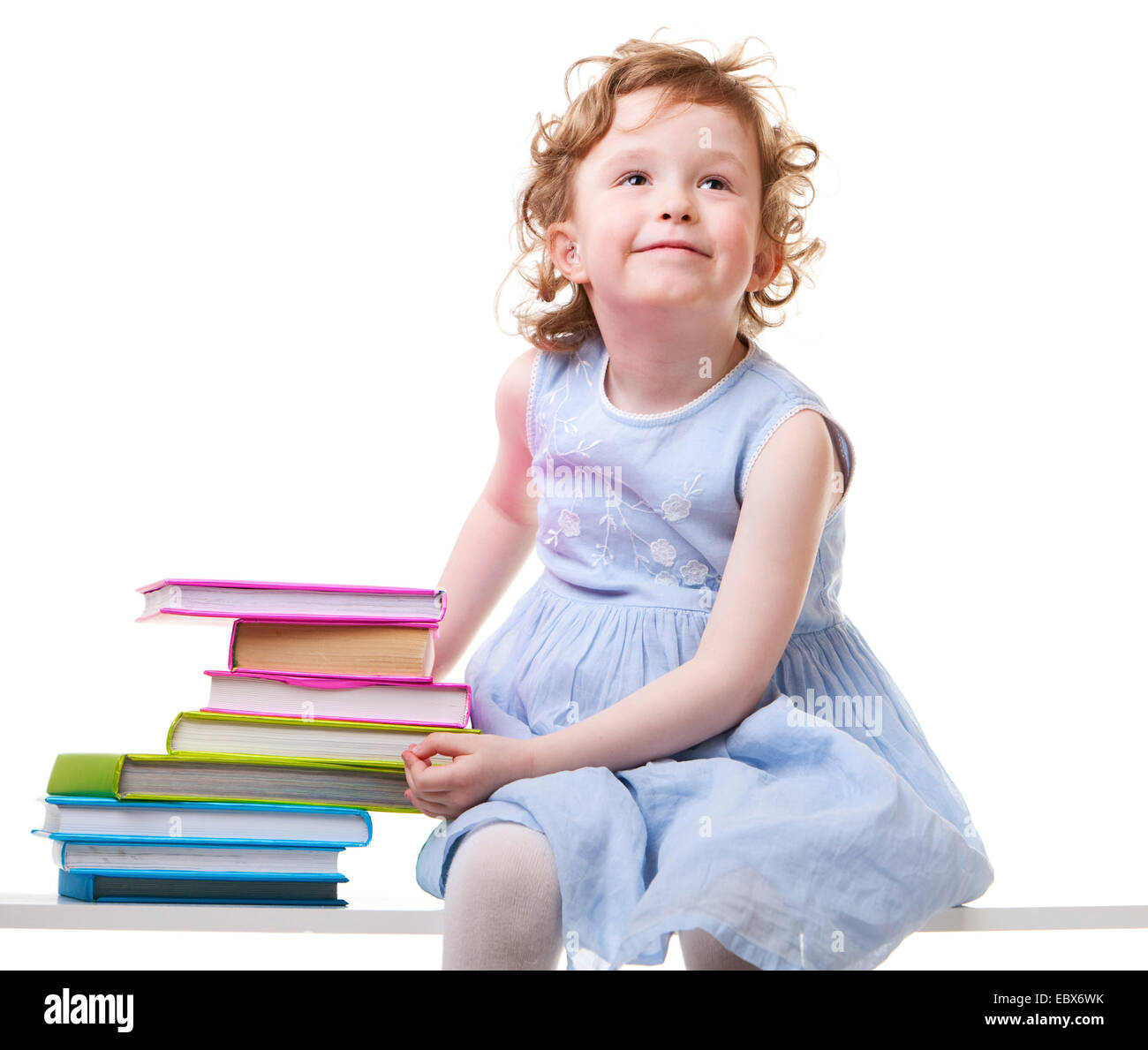 Bambina con libri seduto su una panchina Foto Stock