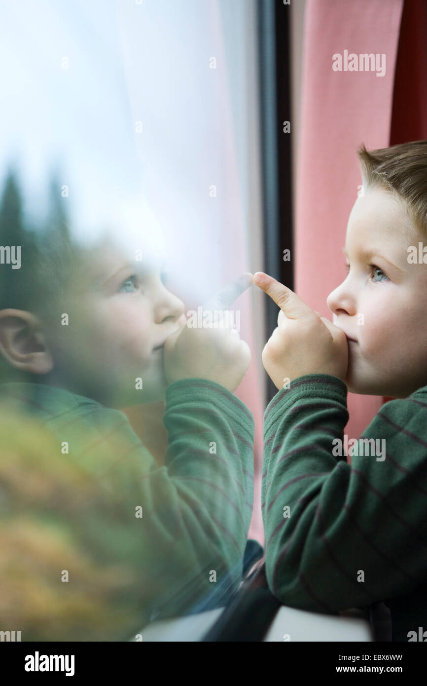 Carino a 4 anni vecchio ragazzo che viaggiano in treno Foto Stock