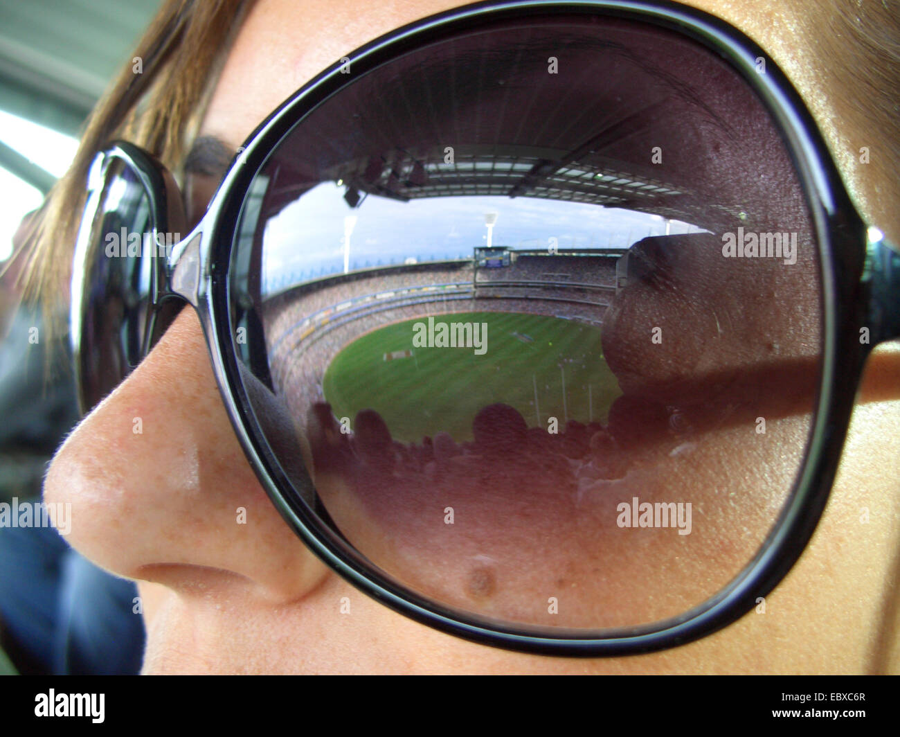 Lo stadio di calcio di mirroring in occhiali da sole di una donna, Australia Nuovo Galles del Sud di Sydney Foto Stock