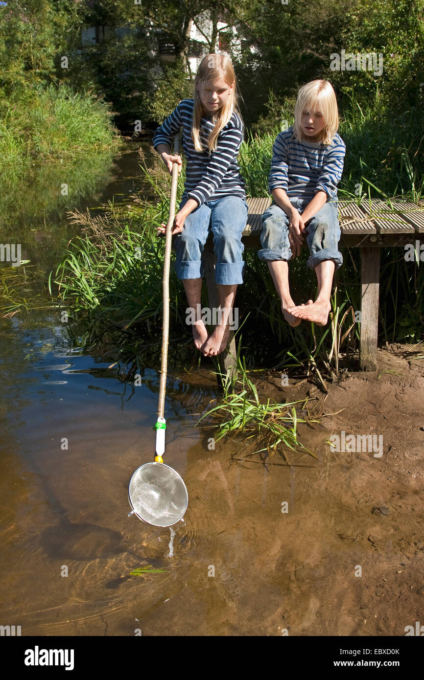 Due bambini con un selfmade brailer, fatta da un cullander Foto Stock