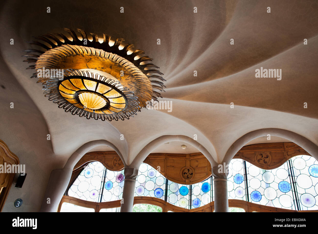 Casa Batllo a Barcellona, Spagna. Il sole a forma di lampada di overhead e vortice a spirale sul soffitto di Antoni Gaudi sul piano nobile. Foto Stock