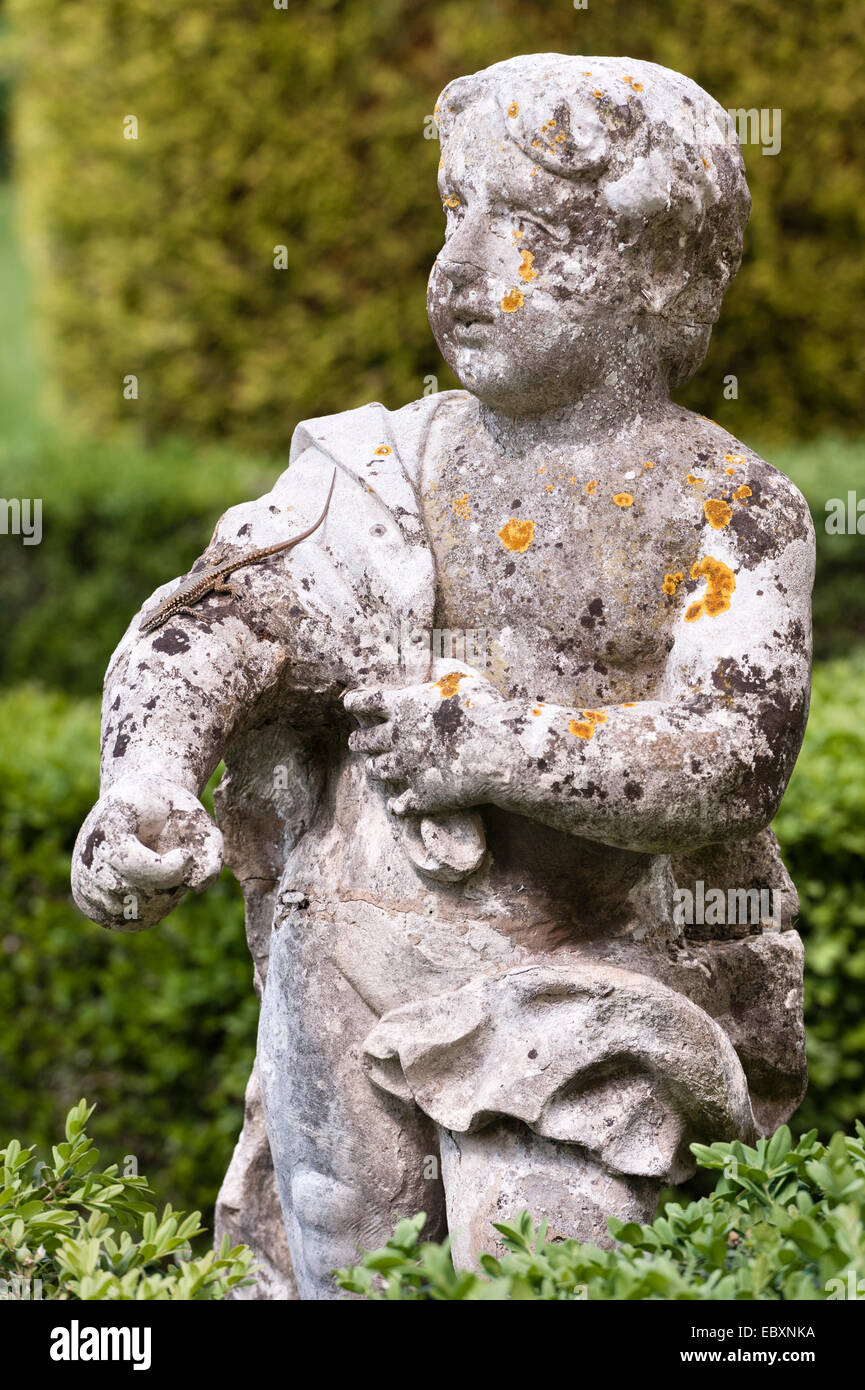 Villa Rizzardi (Giardino di Pojega), Negrar, Italia. Una lucertola corre lungo il braccio di una statua di un ragazzo Foto Stock