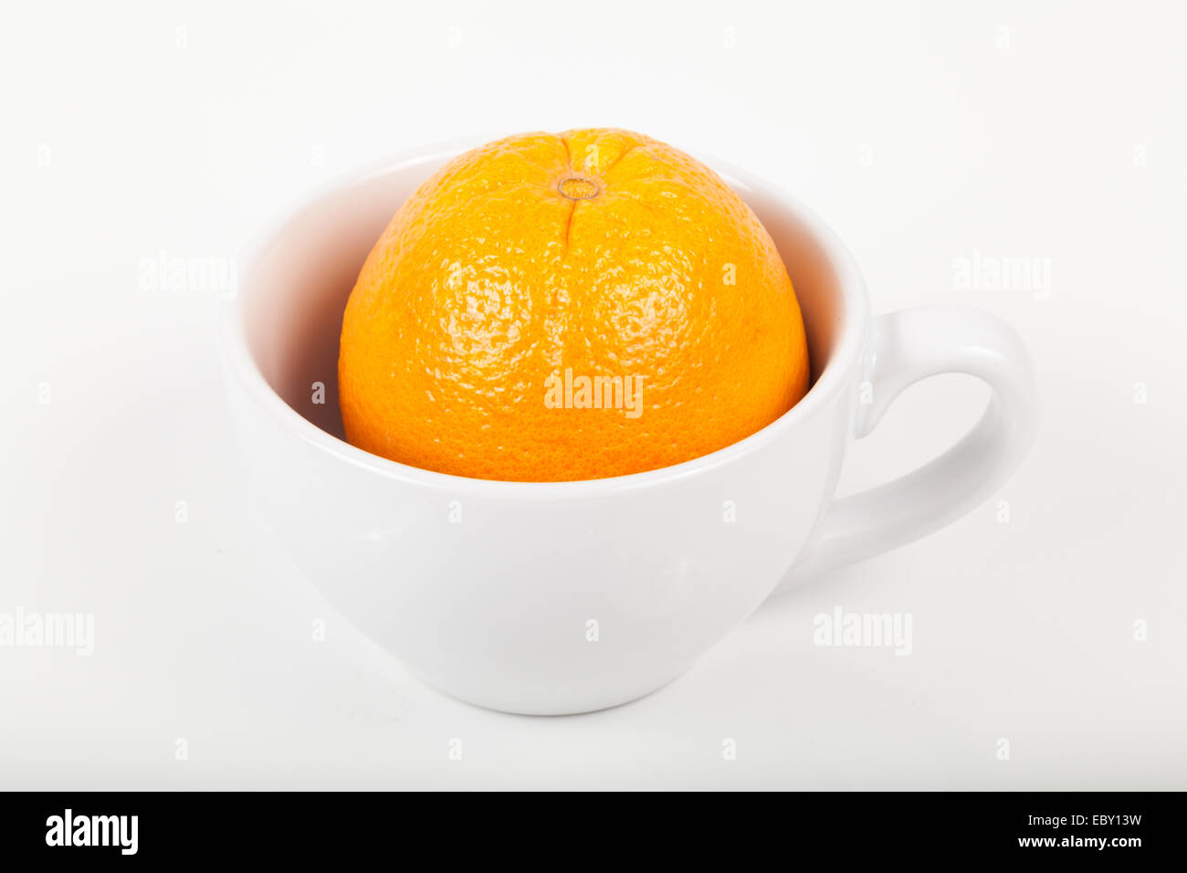 Arancione in una tazza su bianco Foto Stock