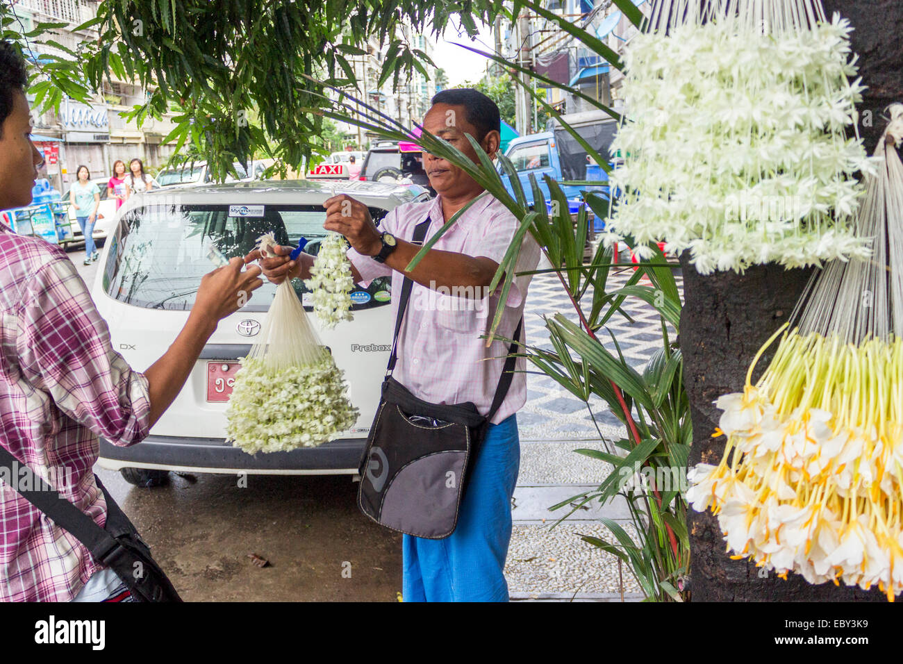 Un uomo vende di gelsomino e fiori bianchi corona per offrire, Yangon, birmania, myanmar Foto Stock