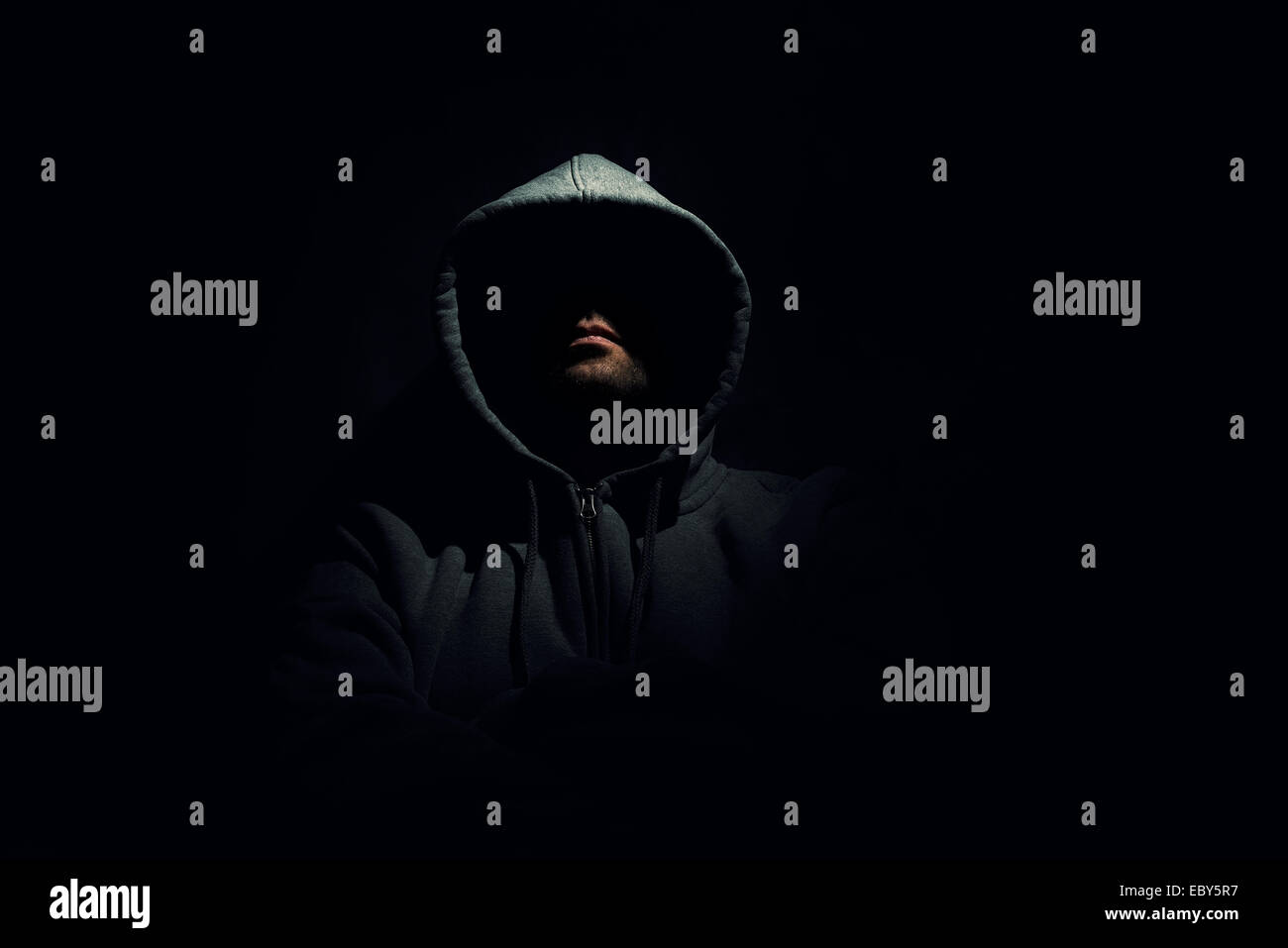 Anonimo uomo che indossa una felpa con cappuccio Felpa circondante scura Foto Stock