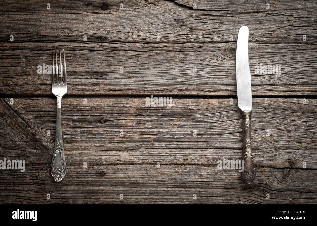Coltello e forchetta su sfondo di legno. Foto Stock