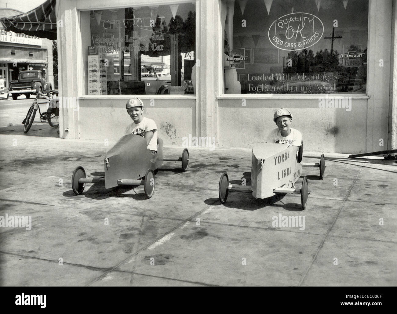 I bambini seduti nei loro soap box derby vetture da corsa a mano dal legno al di fuori di una Chevrolet concessionaria auto nel 1953 in Yorba Linda, California. Chevrolet è lo sponsor del All-American soapbox derby gare. Foto Stock
