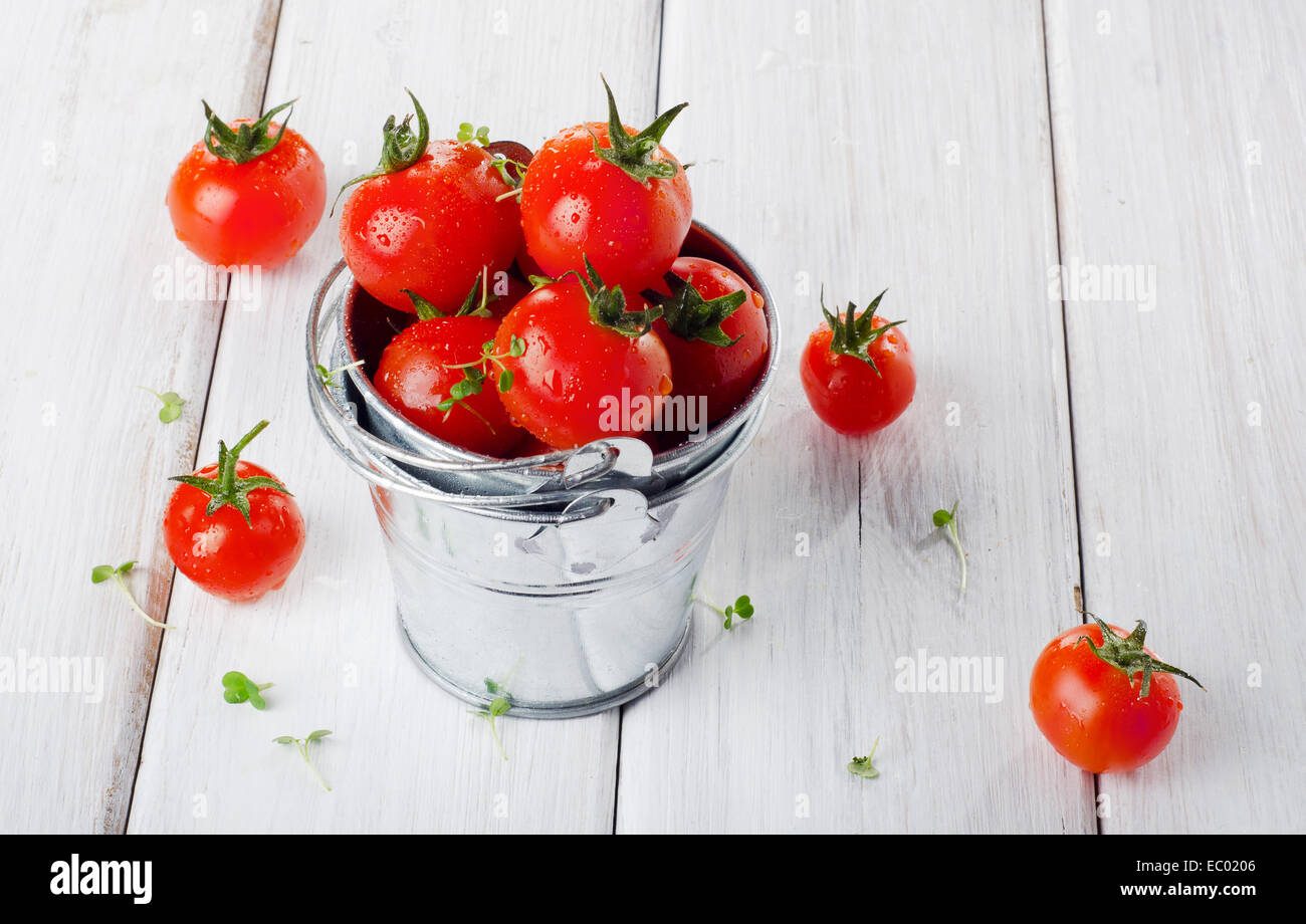 Freschi pomodori ciliegia su un tavolo di legno. Messa a fuoco selettiva Foto Stock