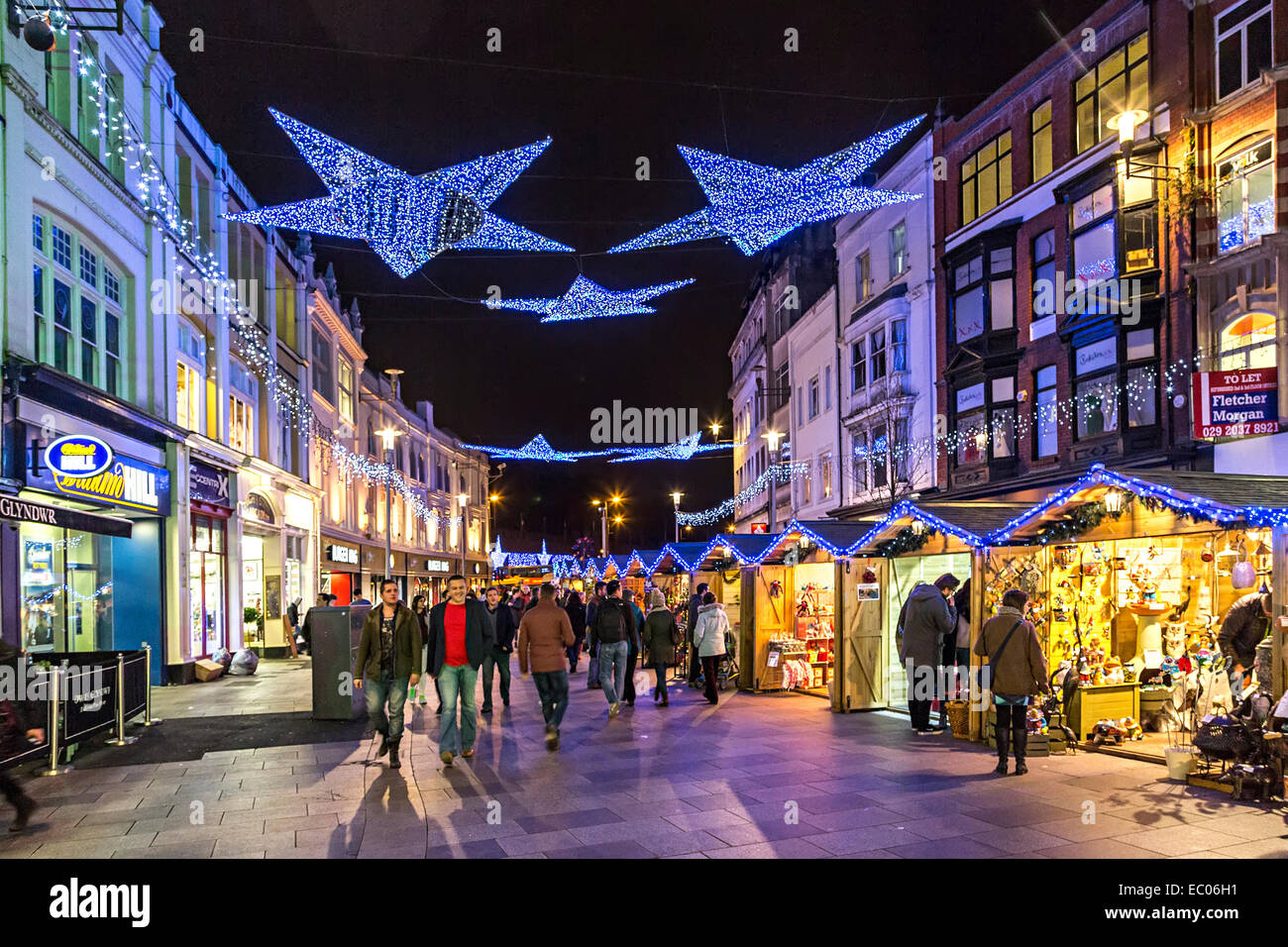 Le decorazioni di Natale e per lo shopping in strada con il mercatino di Natale, Cardiff Wales, Regno Unito Foto Stock