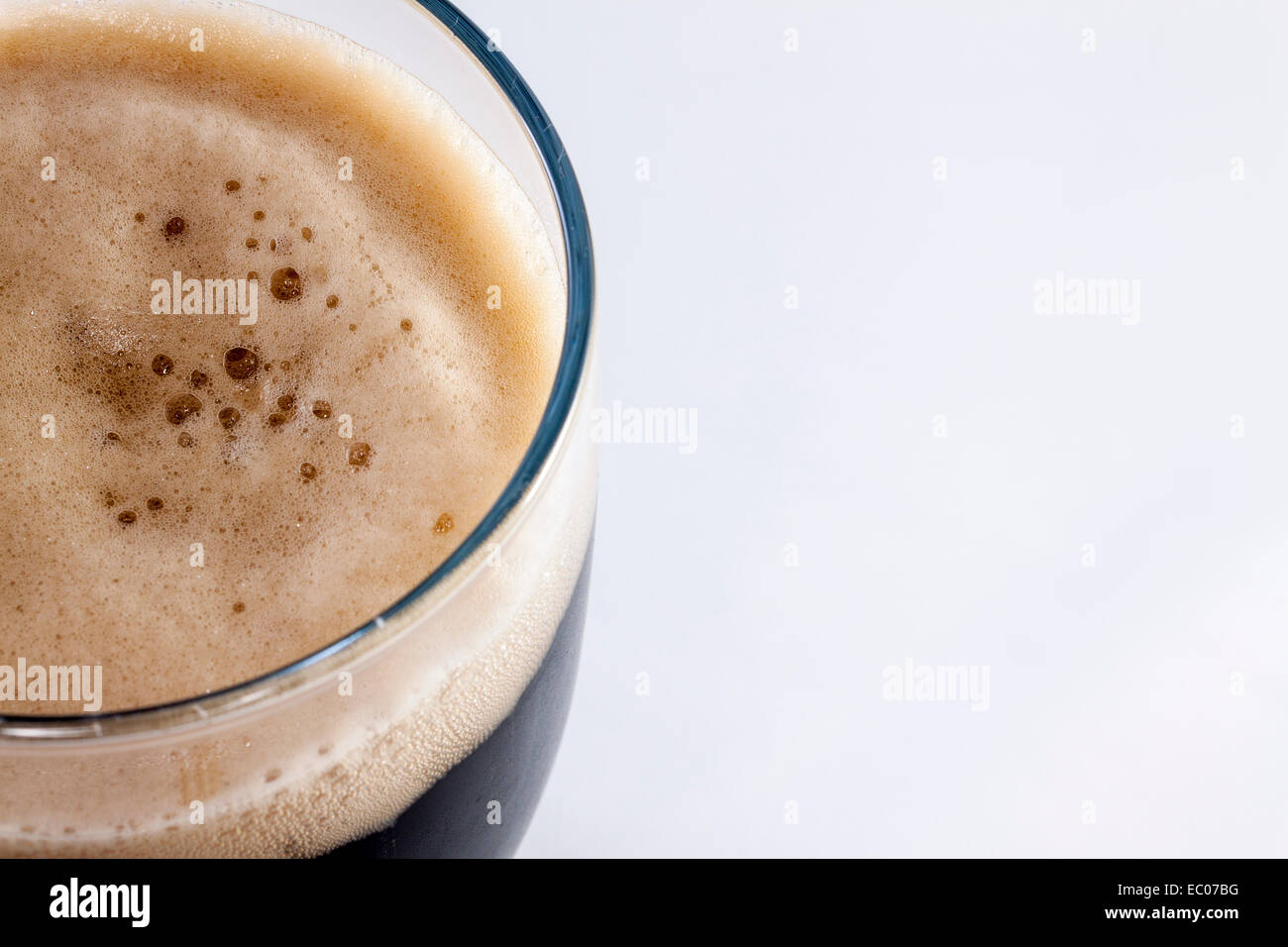 Vetro pinta di stout contro uno sfondo bianco con una stanza per la copia Foto Stock