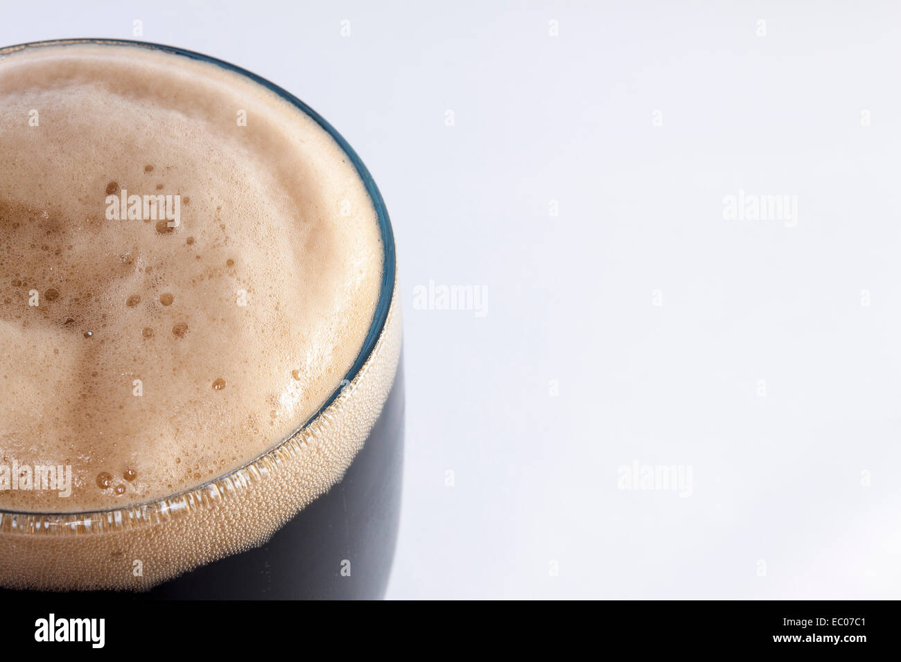Vetro pinta di stout contro uno sfondo bianco con una stanza per la copia Foto Stock