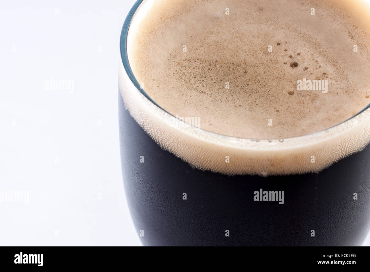 Vetro pinta di stout contro uno sfondo bianco con una stanza per la copia Foto Stock
