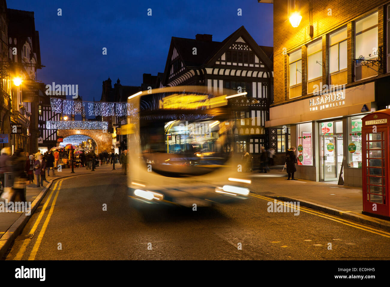 Gli autobus del trasporto pubblico per le strade di Chester, Cheshire; centro città paesaggio serale vacanze di Natale stagione di shopping, negozi al dettaglio, negozi. Regno Unito Foto Stock