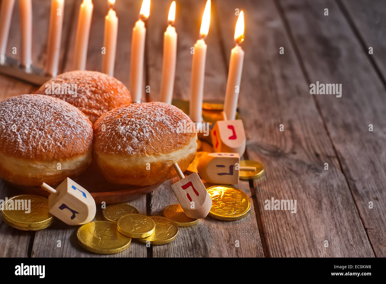 Festa ebraica hannukah simboli - menorah, ciambelle, chockolate monete e dreidels in legno. Copia di sfondo spazio. Foto Stock
