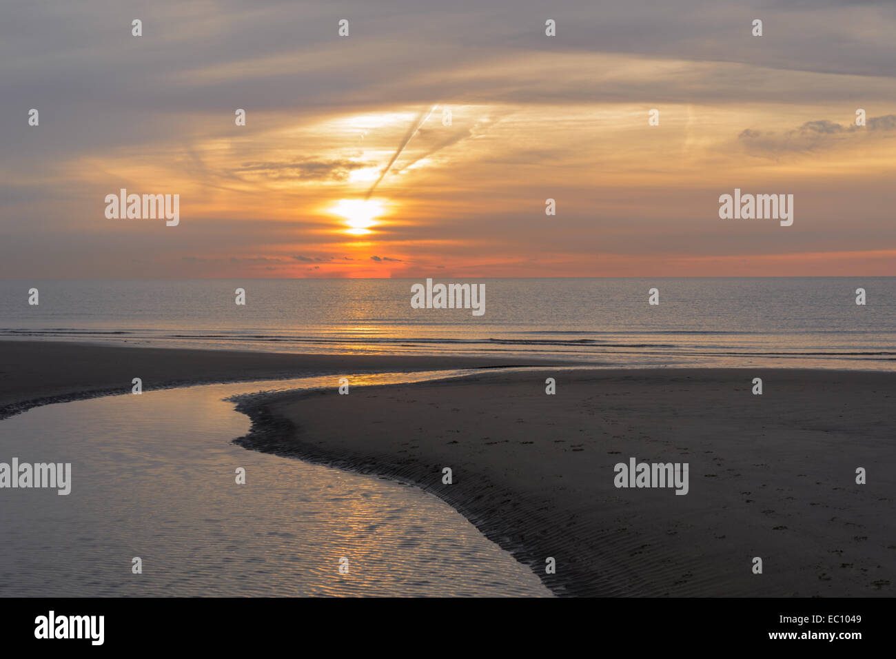 La mattina presto sorgere del sole sulla spiaggia con la bassa marea raffigurante un meraviglioso paesaggio marino all'alba Foto Stock