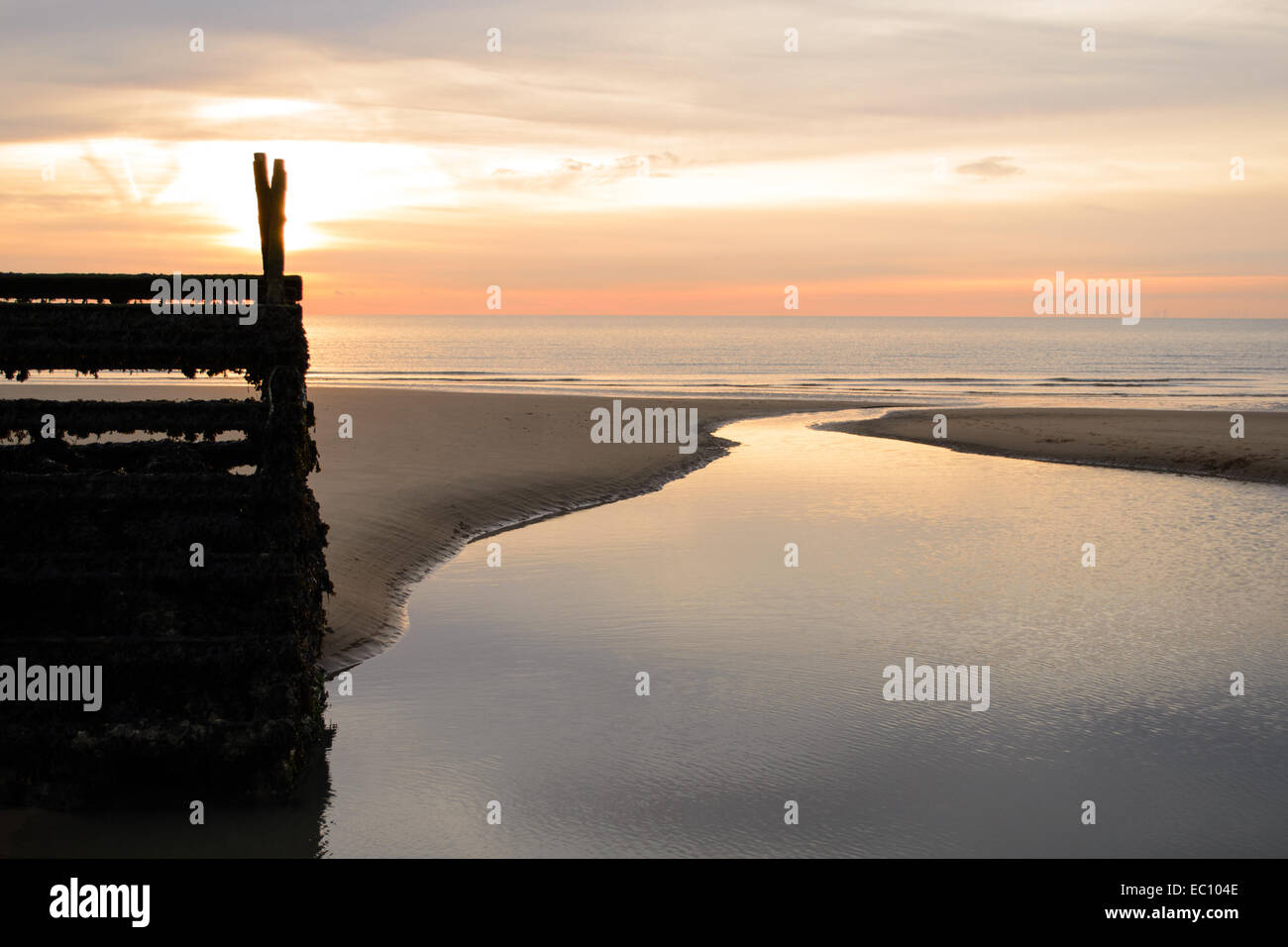 La mattina presto sorgere del sole sulla spiaggia con la bassa marea raffigurante un meraviglioso paesaggio marino all'alba Foto Stock