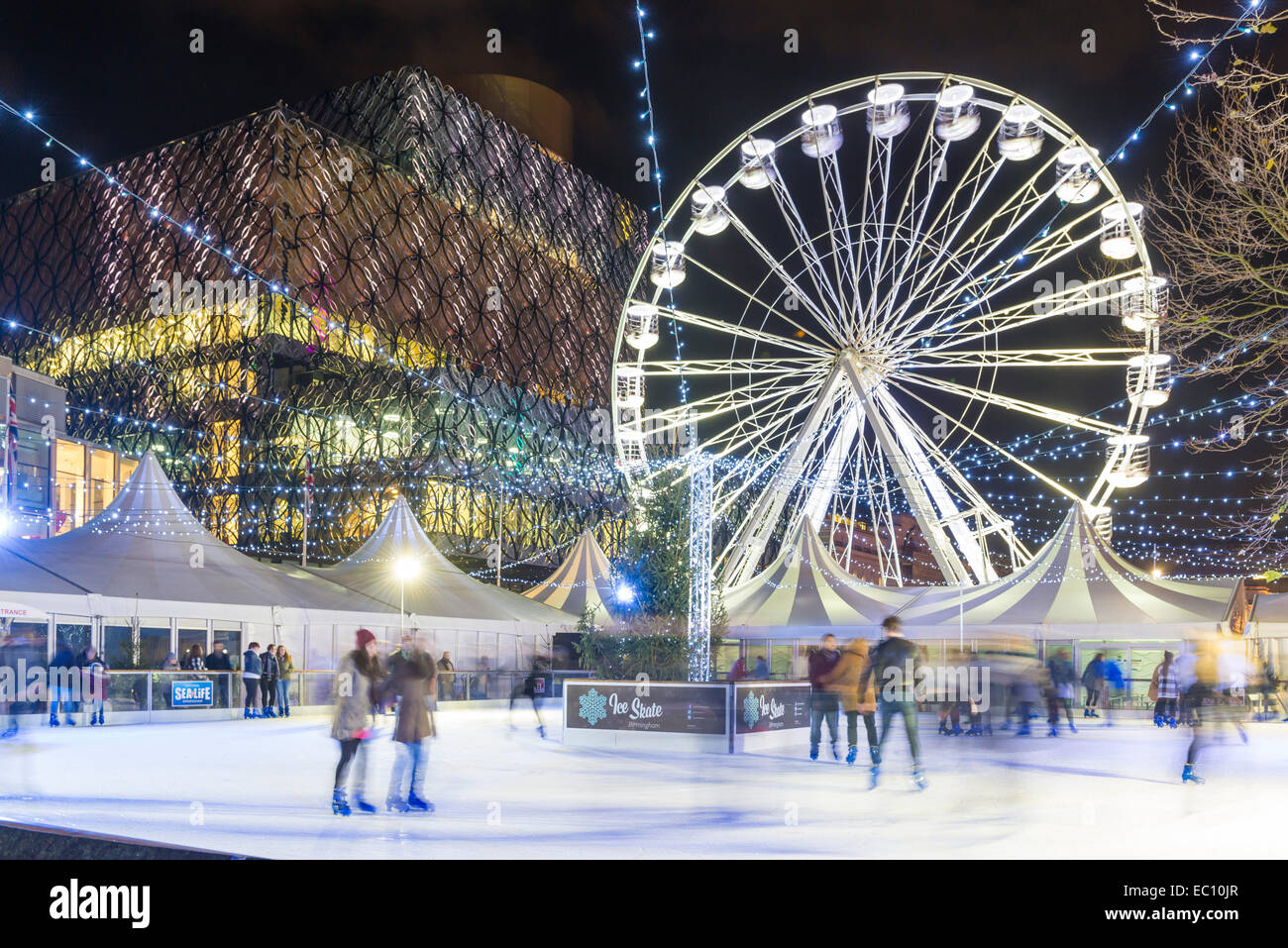 Il Natale pista di pattinaggio e la grande ruota al di fuori della biblioteca di Birmingham in Centenary Square. Foto Stock