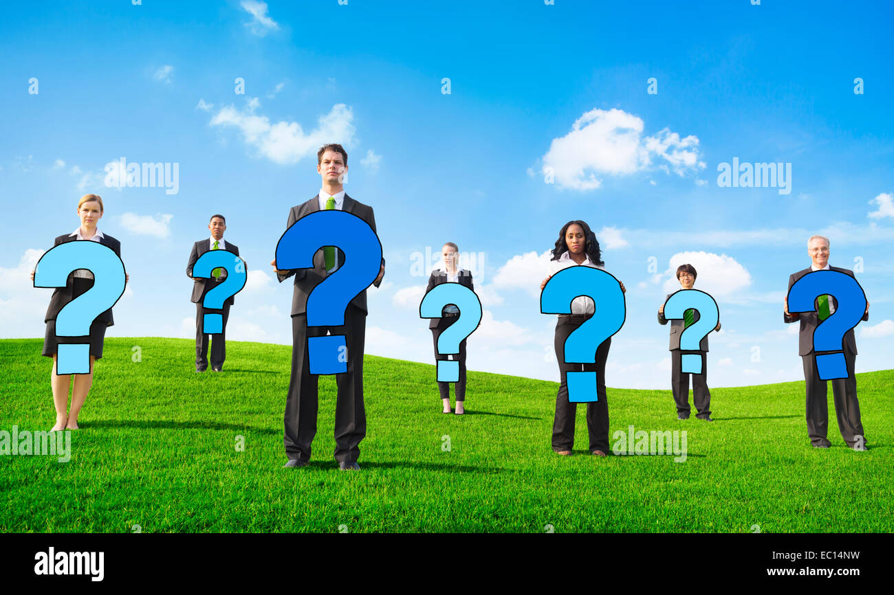 Adirato contro la gente di affari esterni tenendo premuto un punto interrogativo Foto Stock