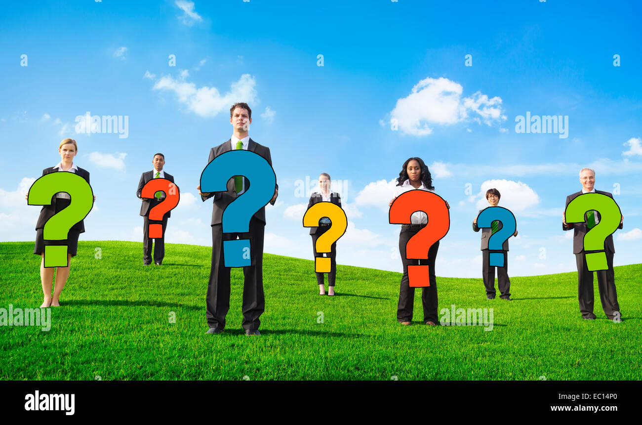 Adirato contro la gente di affari esterni tenendo premuto un punto interrogativo Foto Stock