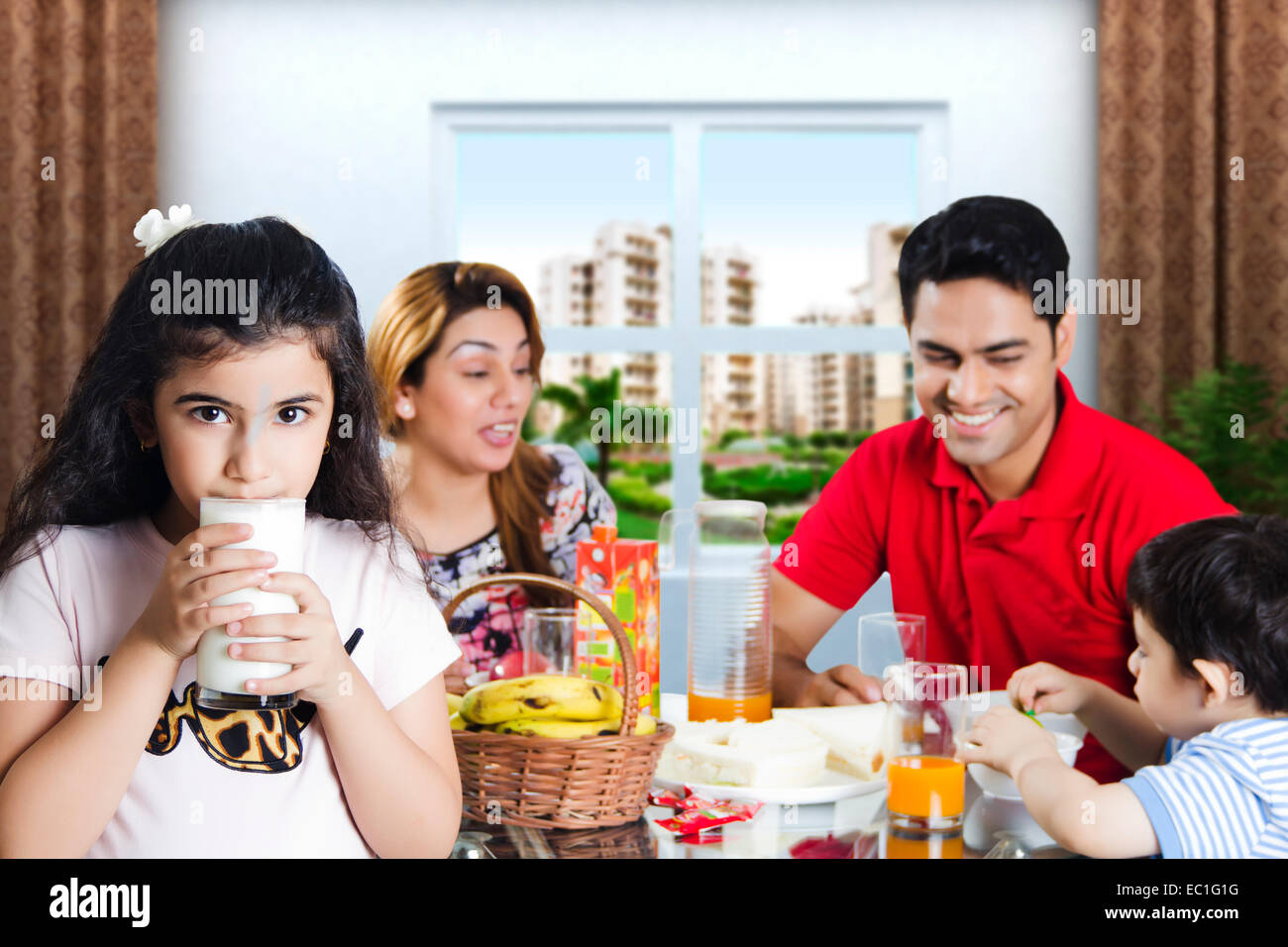 Indian genitori con bambino prima colazione Foto Stock