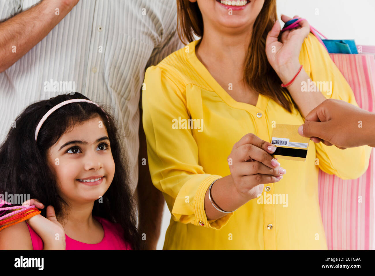 Indian genitori con bambino Shopping pagamento con carta di credito Foto Stock