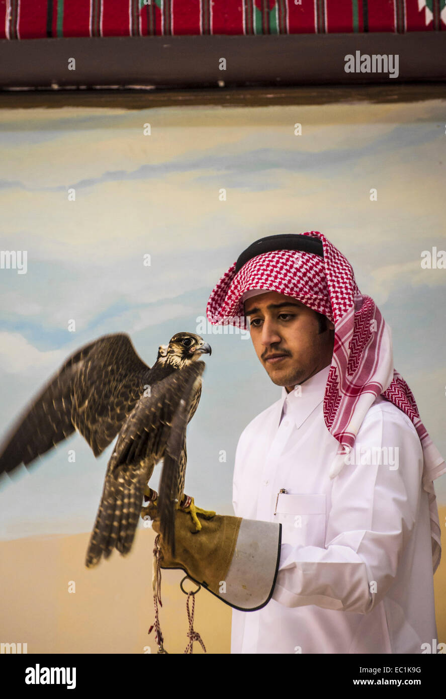 Arab esaminando falcon nella città di Doha shop. Il Falcon è uccello nazionale degli Emirati arabi uniti, Qatar, Arabia Saudita e Oman, un simbolo di status per royal famiglie arabe. La Falconeria è un sport preferito nella Penisola Arabica, mantenendo il patrimonio del deserto. Il prezzo dei falchi sul mercato Qatar è salito a più di US$275k, bouoyed da un aumento della domanda interna sul retro di un recente festival. Foto Stock