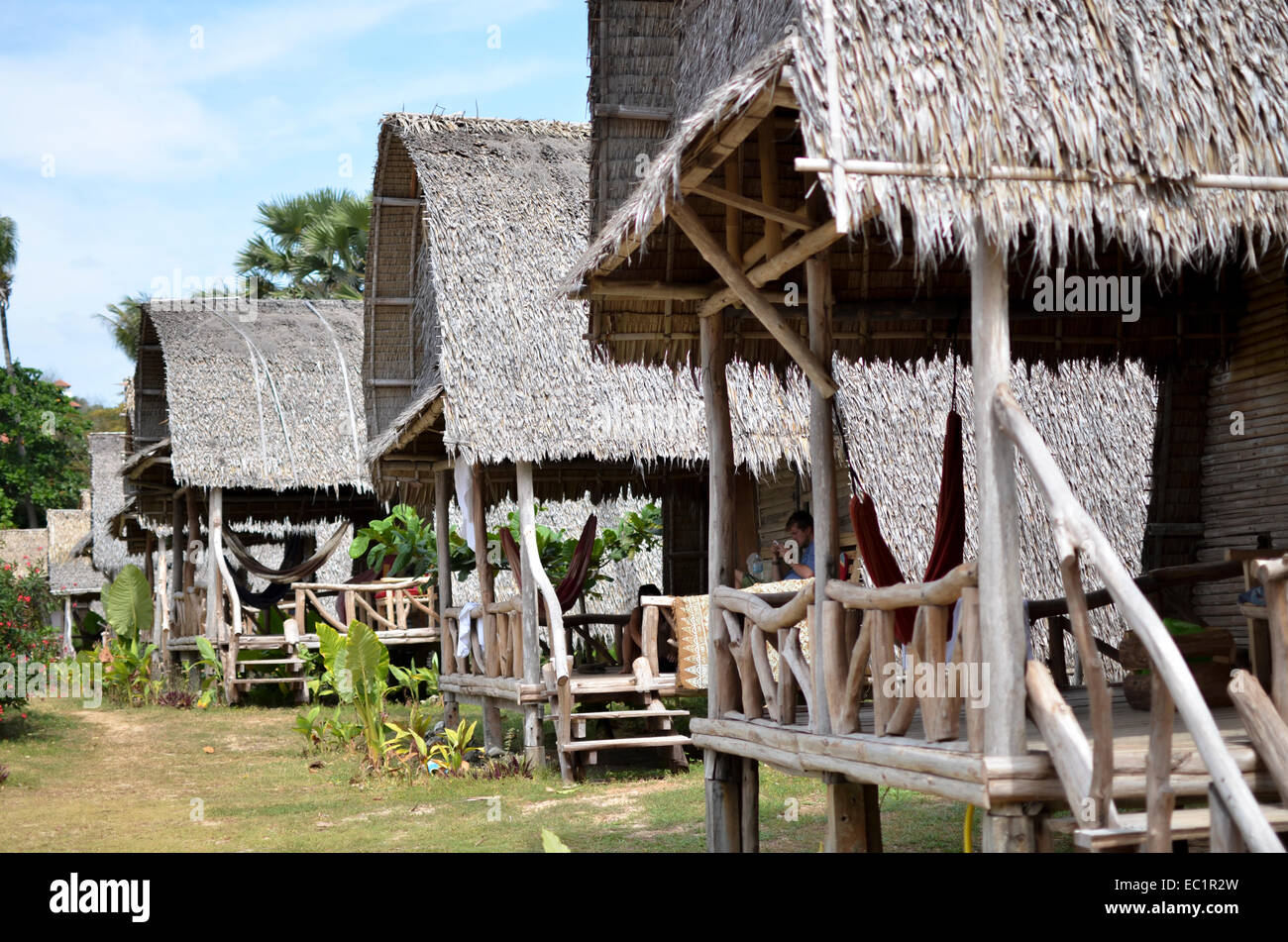 Fila di spiaggia turistica di capanne con tetti di paglia, Koh Lanta, Thailandia Foto Stock