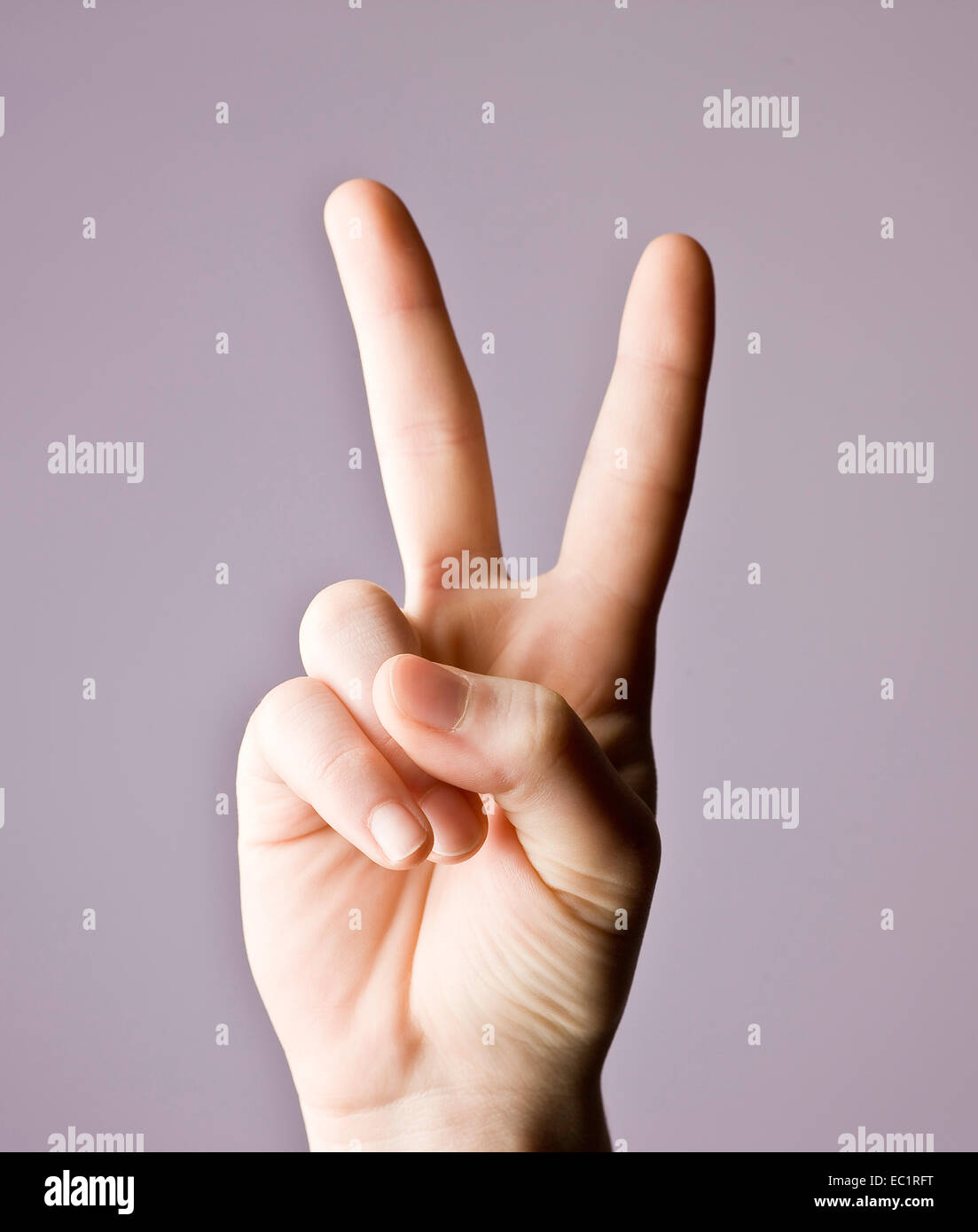 Man mano che indica la pace segno di vittoria. Il V segno è un gesto a mano il cui indice e medio le dita sono sollevate e parted Foto Stock