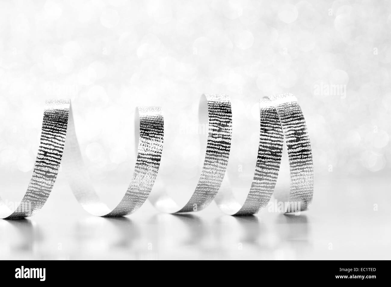 Curly argento regalo nastro su luccica sullo sfondo di close-up Foto Stock