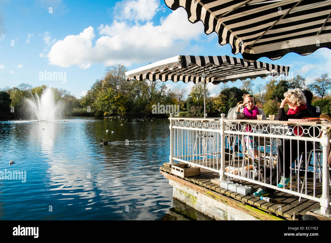 Terrazza bar che si affaccia sul lago con una fontana, Victoria Park, Hackney, Londra, Regno Unito Foto Stock