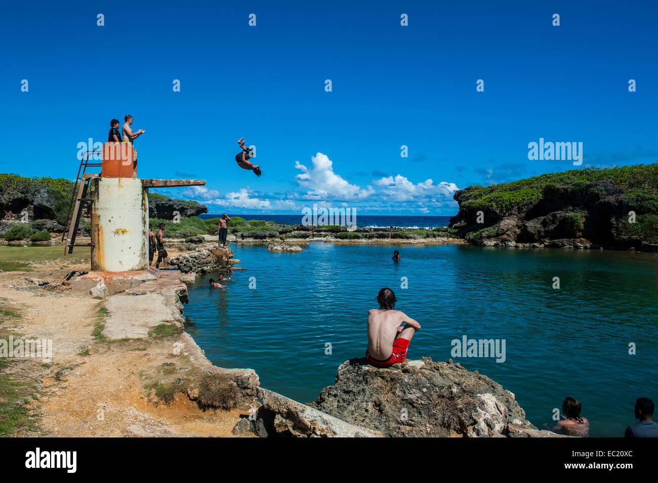 Ragazzi locali di salto e nuoto nella piscina Salugula, Guam, territorio statunitense e del Pacifico Foto Stock
