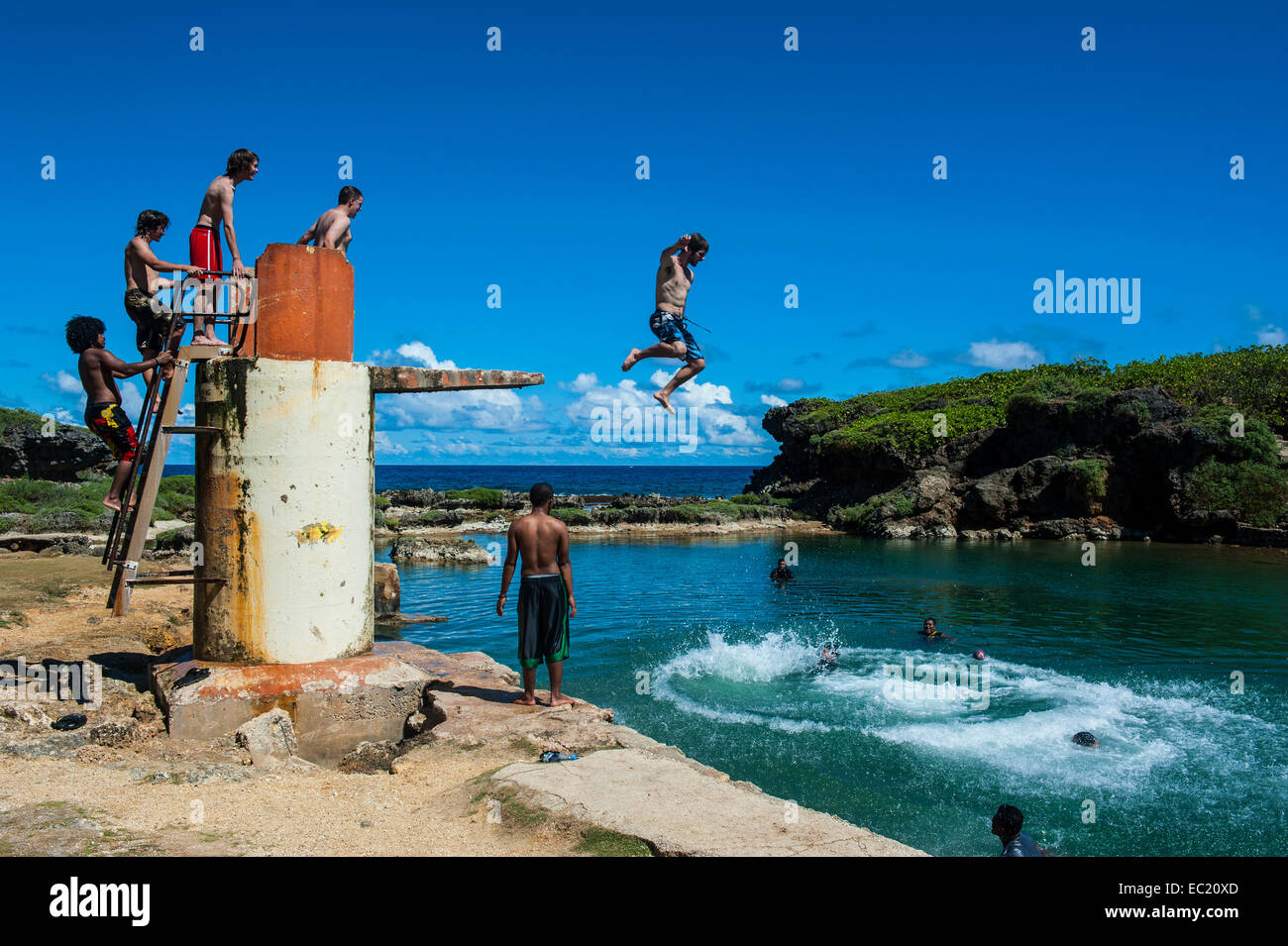 Ragazzi locali di salto e nuoto nella piscina Salugula, Guam, territorio statunitense e del Pacifico Foto Stock