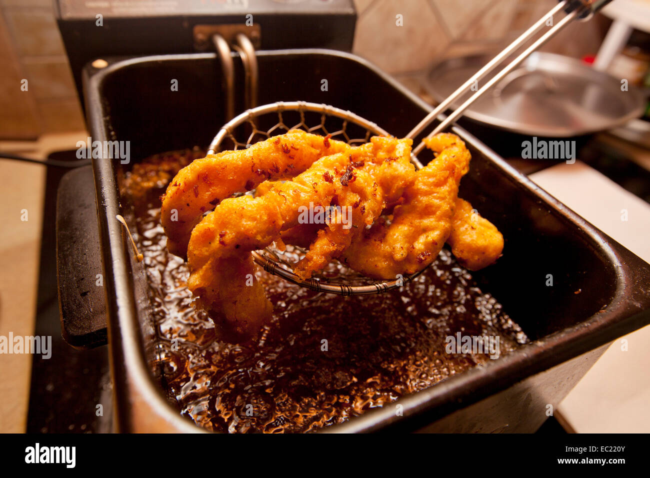 Filetti di pollo fritto in una friggitrice. Foto Stock