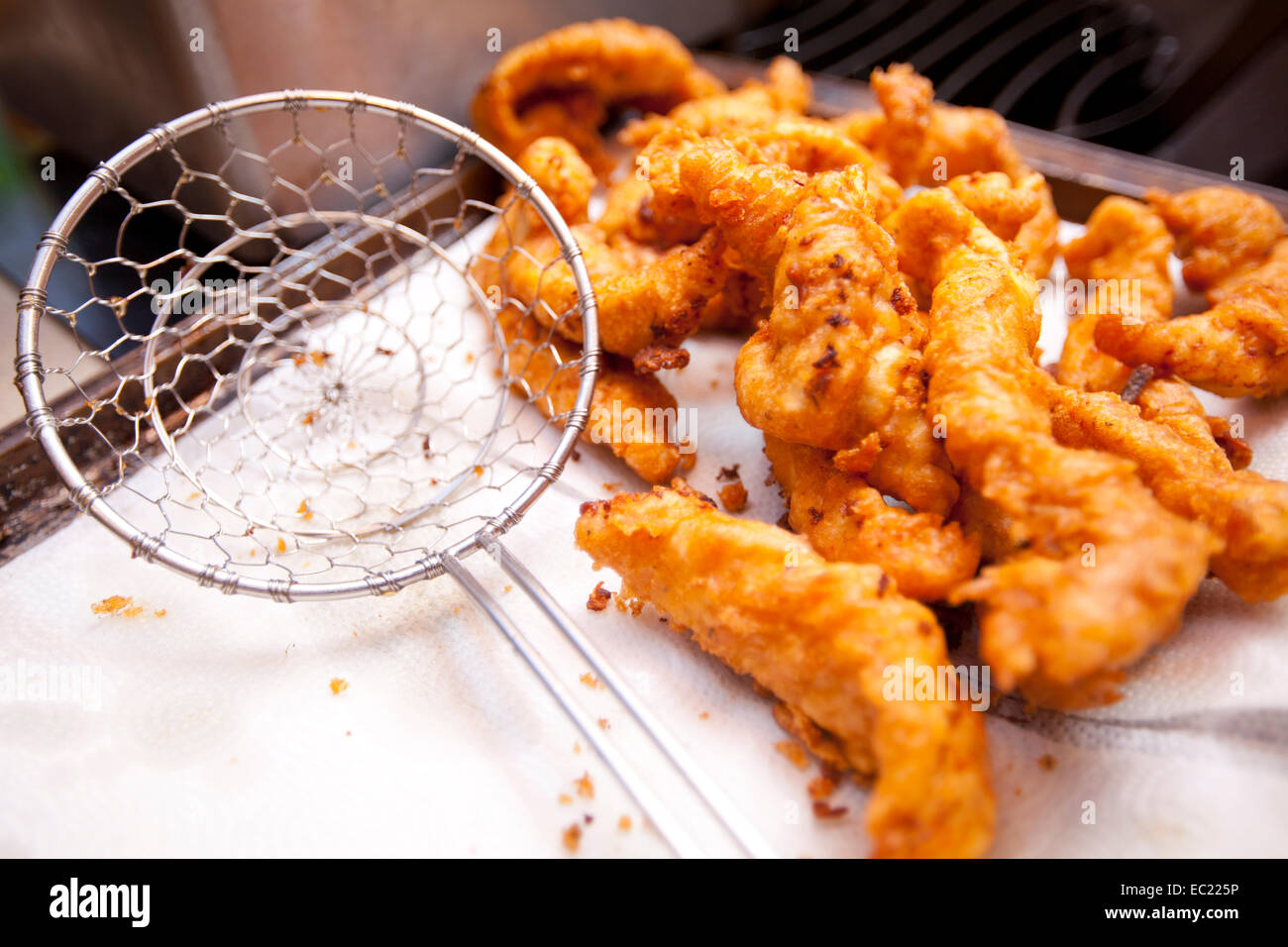 Croccante di pollo fritto offerte raffreddare su un tovagliolo di carta dopo essere stato cotto in una friggitrice. Foto Stock