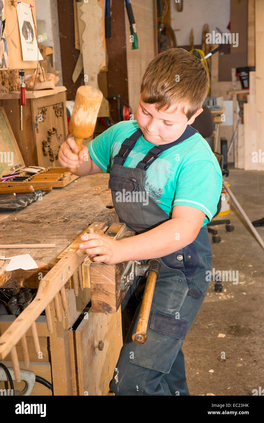 Il contadino figlio di riparazione di un rastrello di fieno, installazione di nuovi denti, Sprenger fattoria di famiglia, Schwaz famiglia distretto, Tirolo, Austria Foto Stock