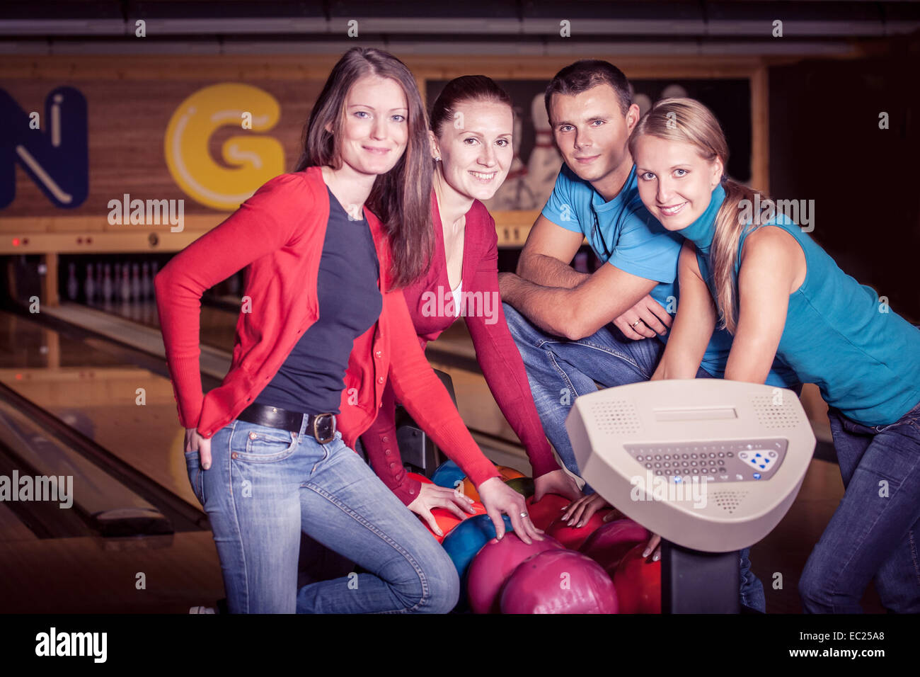 Un gruppo di giovani persone che giocano a bowling Foto Stock