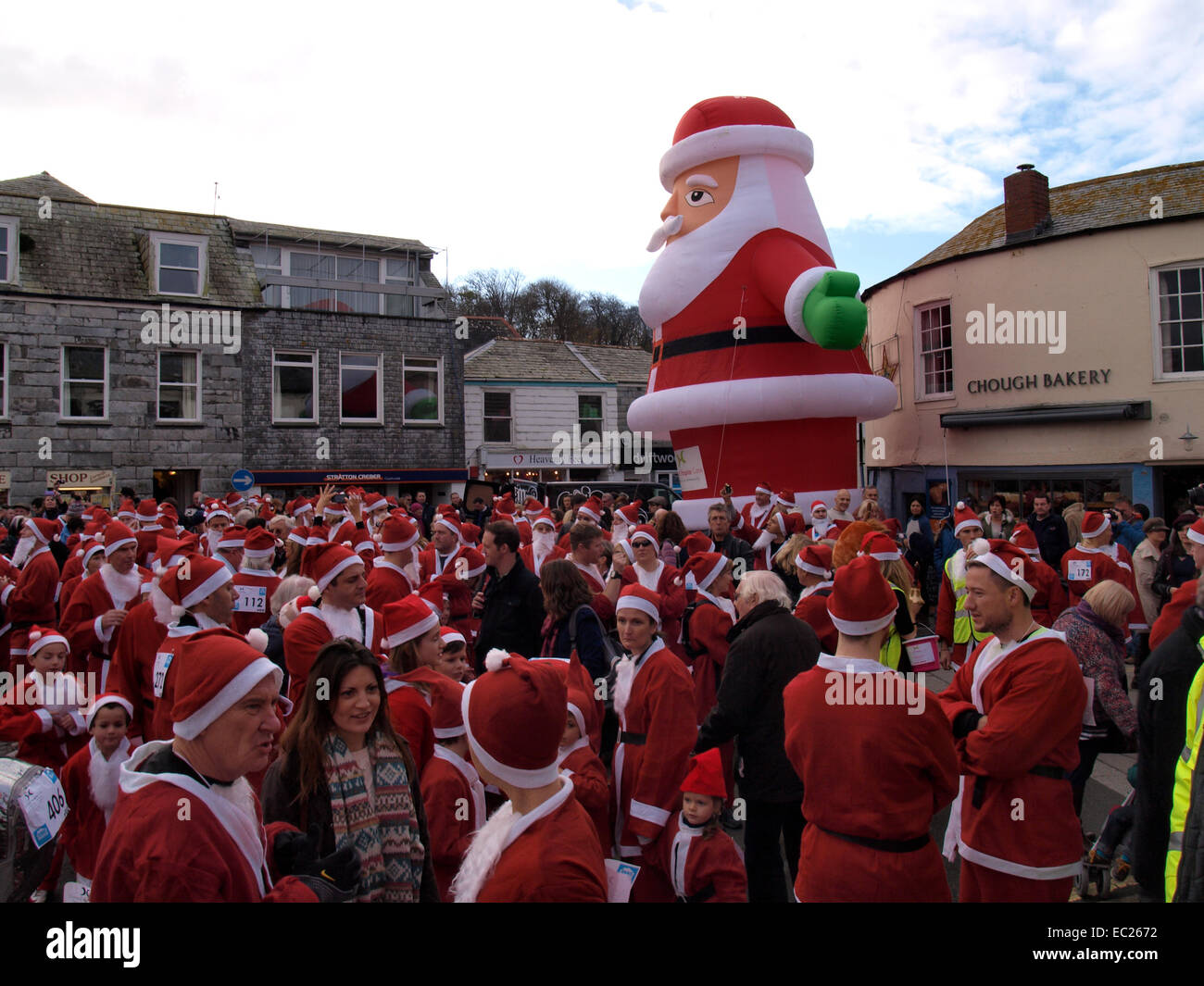 Un sacco di Babbo Natale in attesa per l'inizio della carità Santa gara a Padstow festival di Natale, Cornwall, Regno Unito Foto Stock