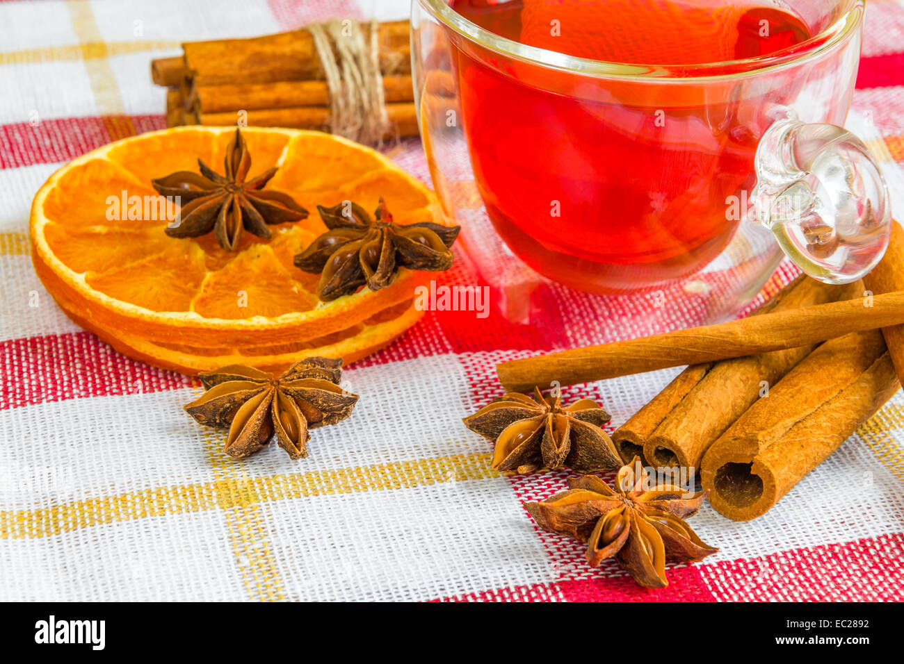 Un paio di stelle di anice, cassia bastoncini di cannella, essiccato anelli arancioni e tè di frutta sulla tovaglia Foto Stock